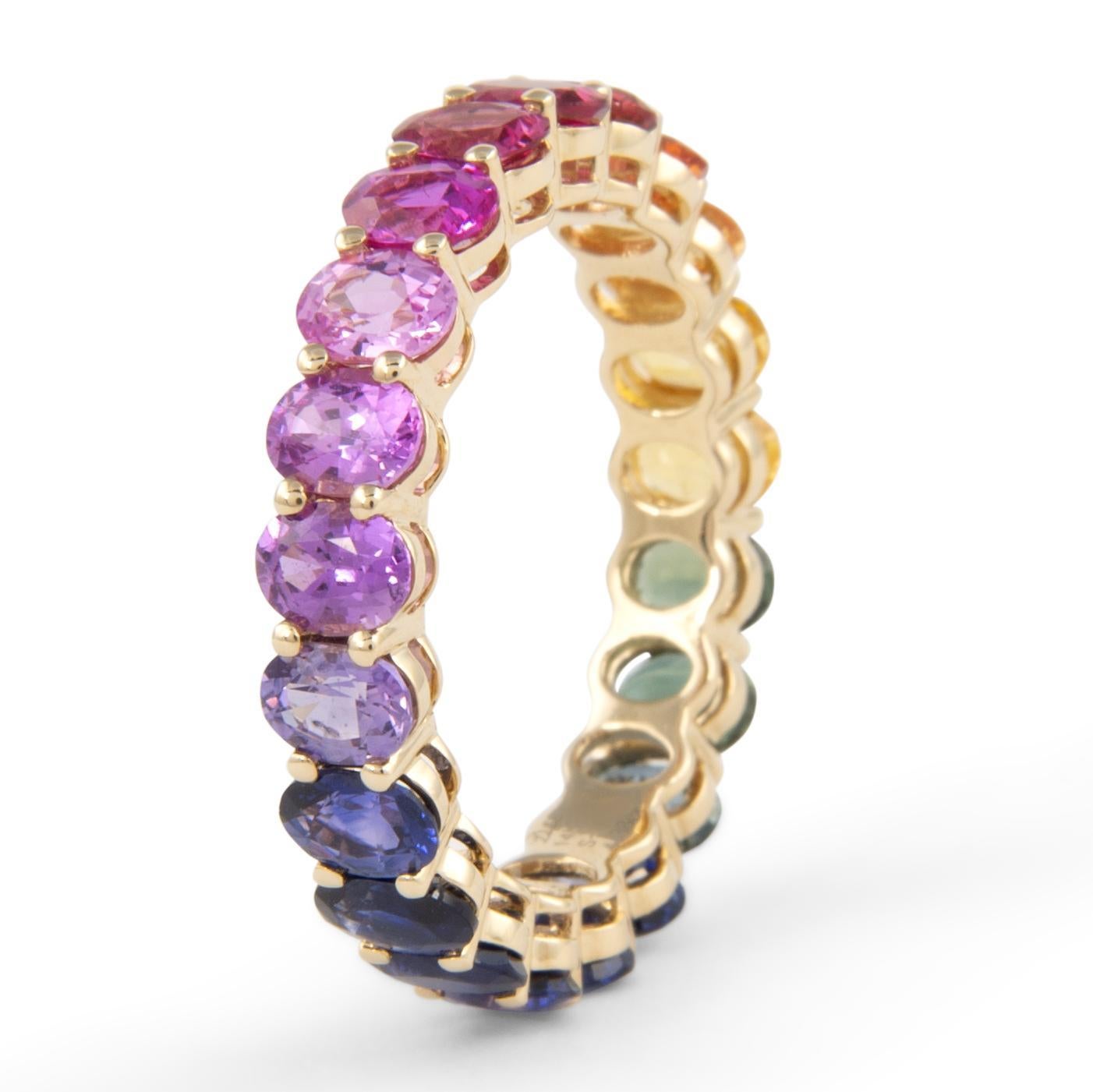 Modern rainbow sapphire eternity band. By Alexander Beverly Hills.
21 oval cut multi color sapphires, heat, 4.38 carats. Prong set in 14-karat yellow gold, 2.91g, ring size 6.25.
Accommodated with an up-to-date digital appraisal by a GIA G.G. once