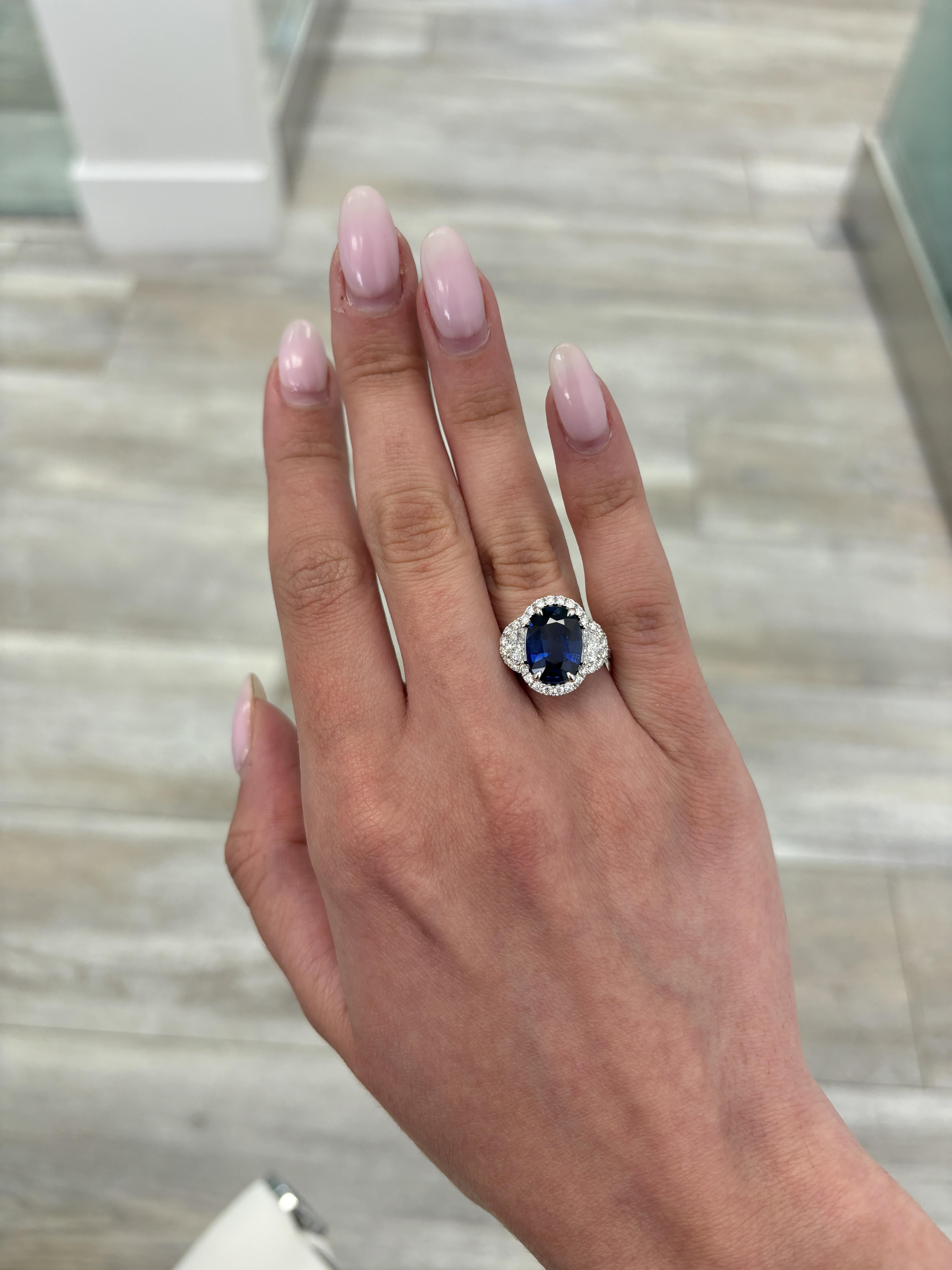 Atemberaubender marineblauer Saphirring mit diamantenem Halo-Dreisteinring von Alexander Beverly Hills. 
5.58 Karat Gesamtgewicht der Edelsteine.
4,46 Karat ovaler Saphir, Hitze. Ergänzt mit 2 Halbmonden und 40 runden Brillanten, 0,90 Karat.