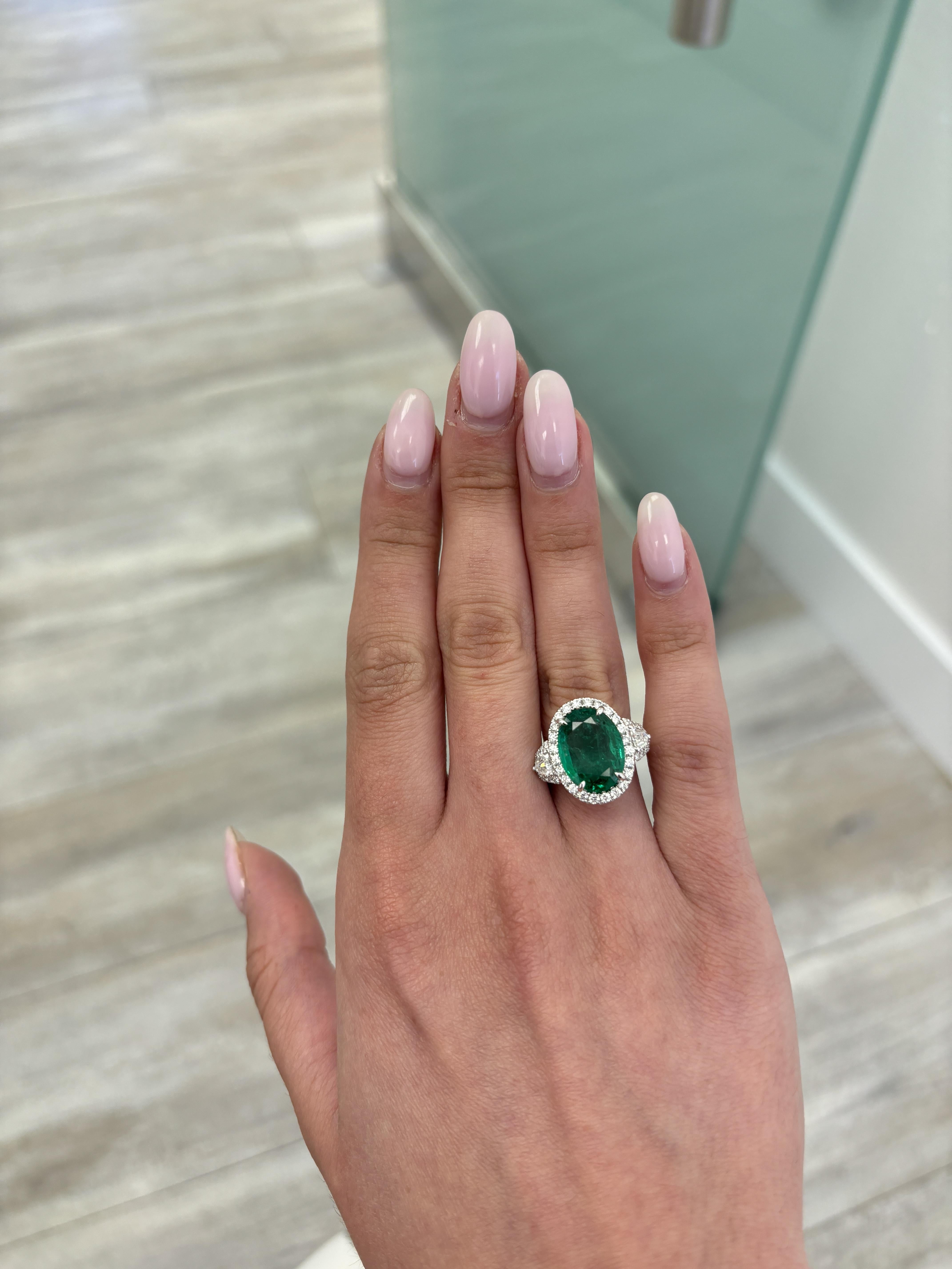 Stunning vivd green emerald of superb color with diamond three stone halo ring, GIA certified. High jewelry by Alexander Beverly Hills.
6.49 carats total gemstone weight.
5.30 carat oval emerald, GIA certified, moderate. 2 sheild diamonds and 50