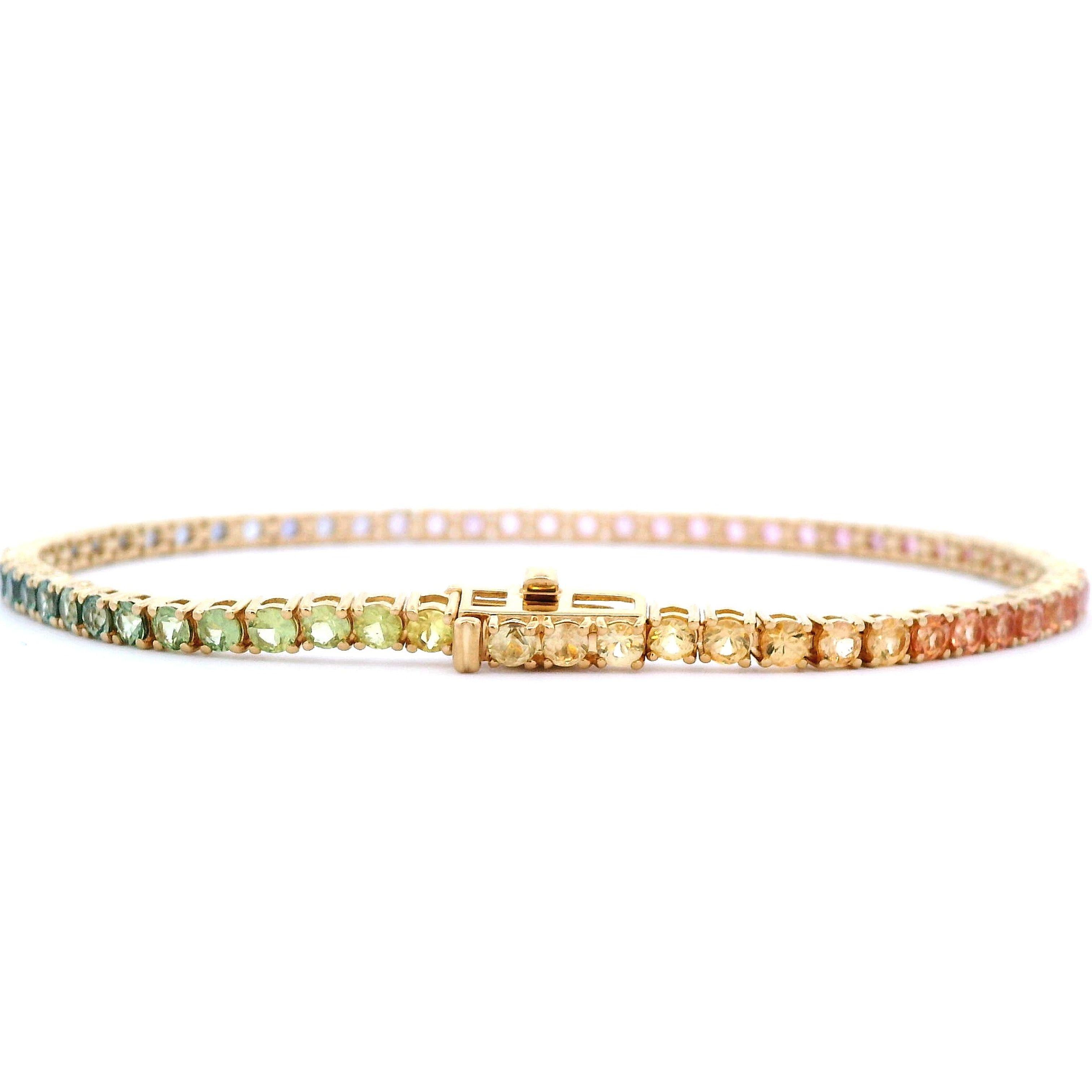 Exquisite and perfectly graduated rainbow multi color sapphire tennis bracelet, by Alexander Beverly Hills.
65 round sapphires, 6.20 carats total. Four prong set in 18k yellow gold, 8.92 grams, 7 inches.
Accommodated with an up-to-date digital