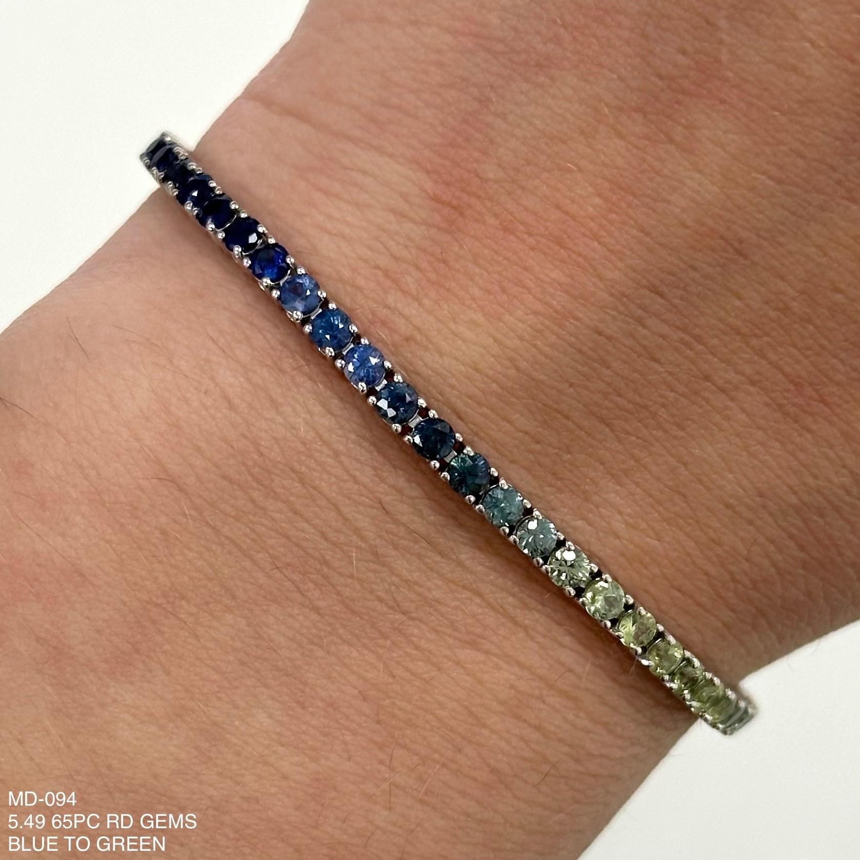 Exquisite and perfectly blended blue to green sapphire tennis bracelet, by Alexander Beverly Hills.
65 round sapphires, 5.49 carats total. Four prong set in 18-karat white gold, 8.46 grams, 7 inches.
Accommodated with an up-to-date digital appraisal