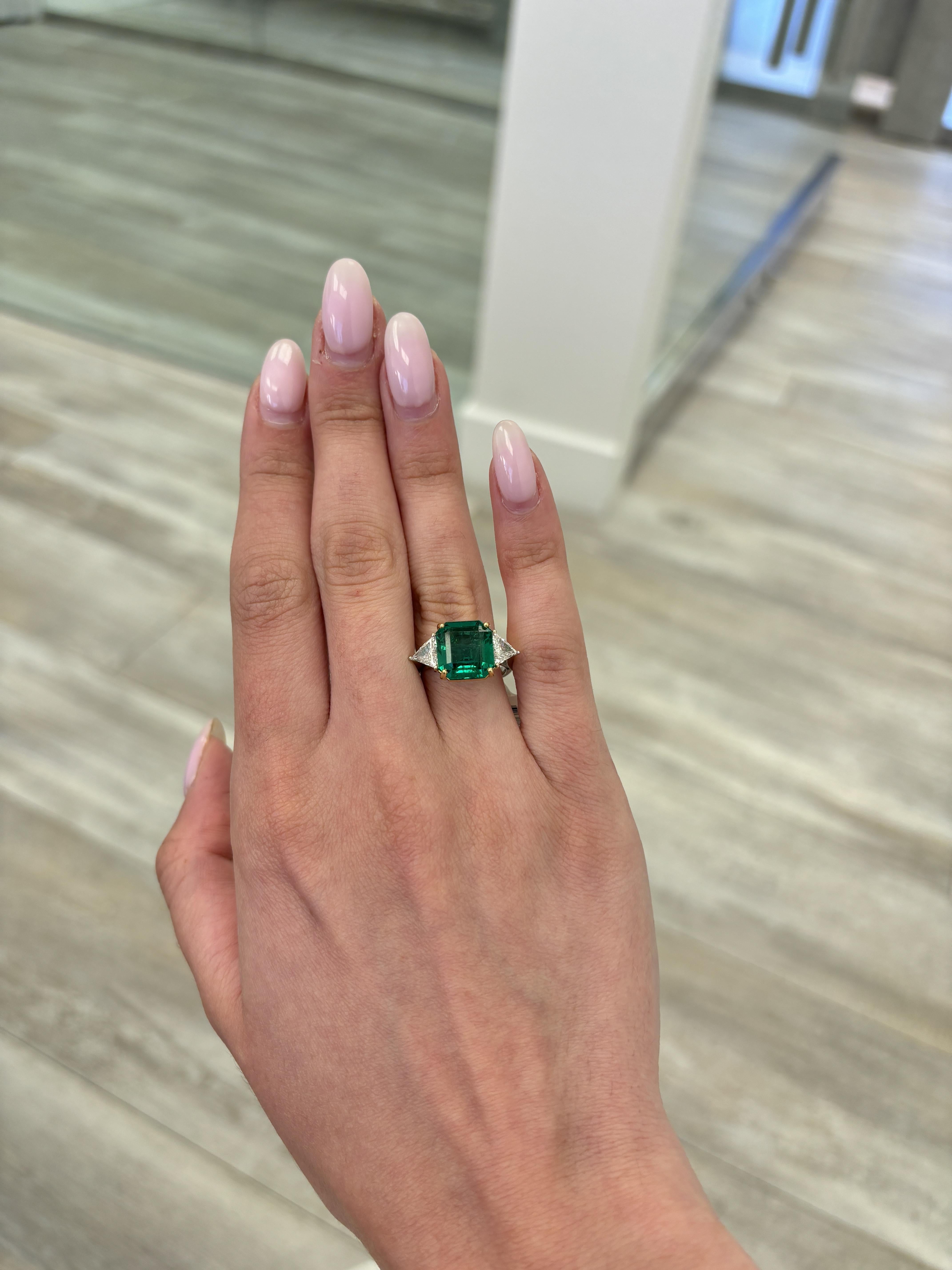 Stunning vivd green emerald of superb color with diamond three stone ring, GIA certified. High jewelry by Alexander Beverly Hills.
6.34 carats total gemstone weight.
5.60 carat emerald cut emerald, GIA certified, moderate. 2 trillion diamonds, 0.74