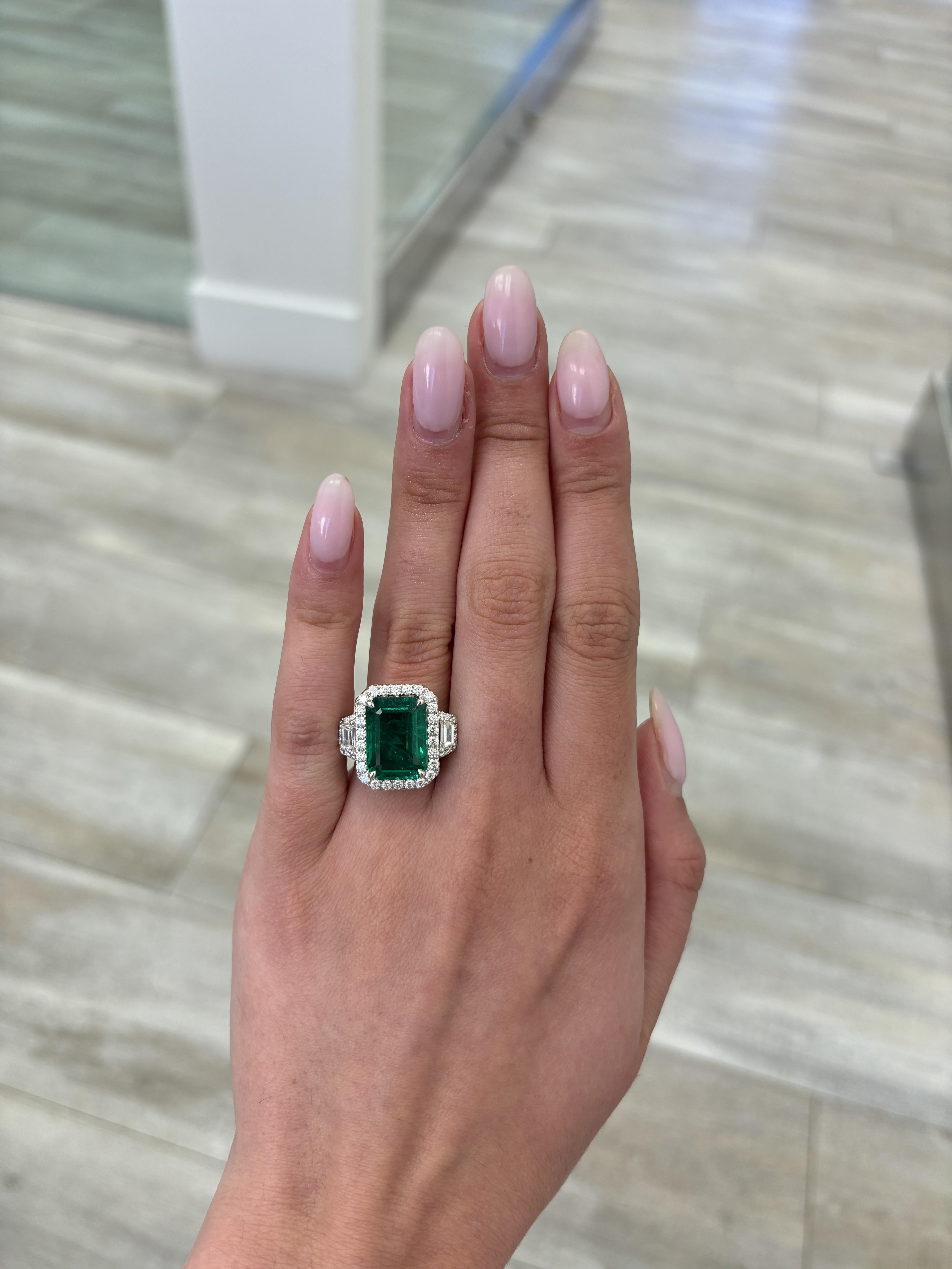 Stunning vivd green emerald of superb color with diamond three stone halo ring, GIA certified. High jewelry by Alexander Beverly Hills.
7.45 carats total gemstone weight.
6.09 carat emerald cut emerald, GIA certified, moderate. 2 trapezoid diamonds
