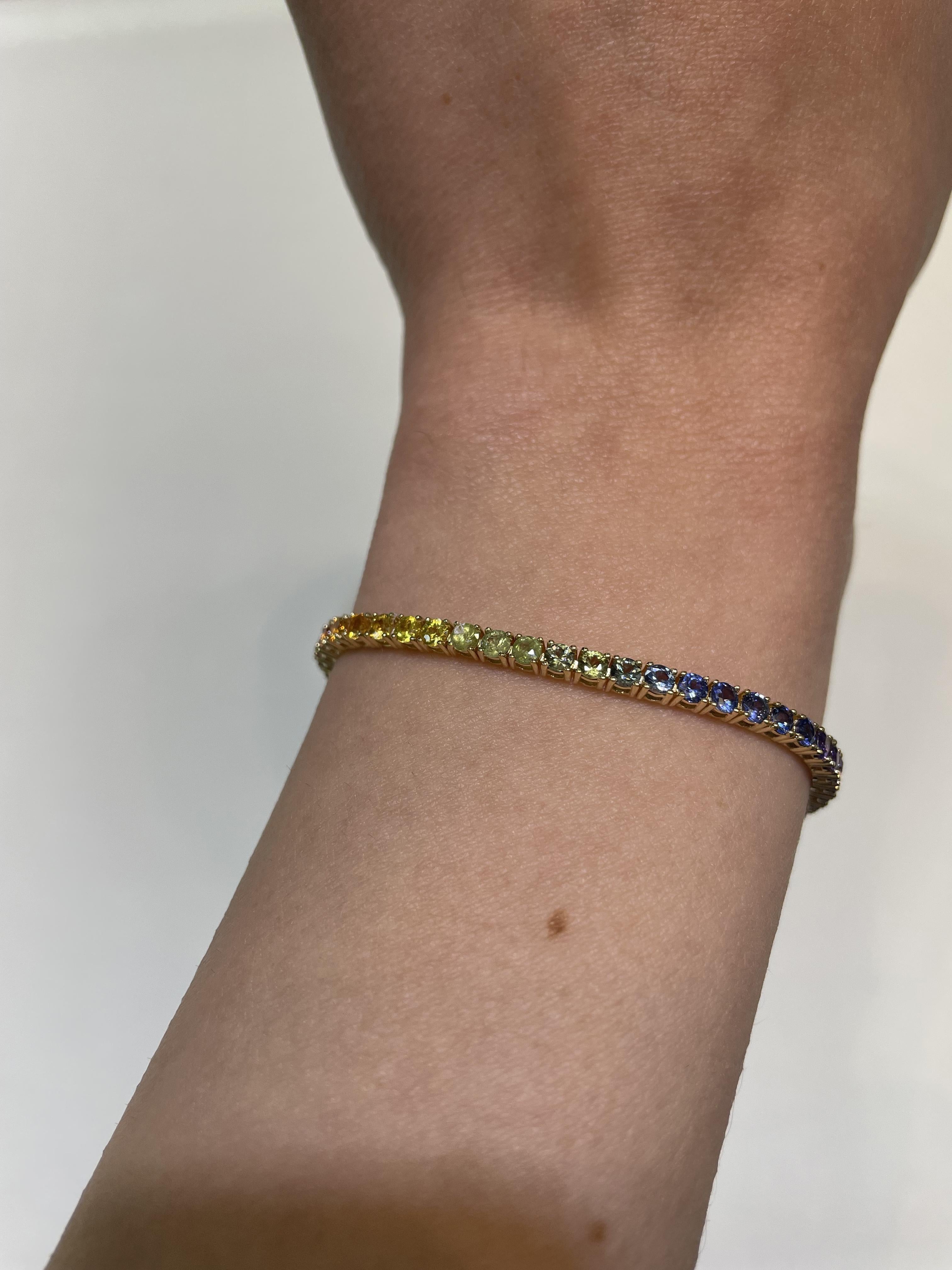 Exquisite and perfectly graduated rainbow multi color sapphire tennis bracelet, by Alexander Beverly Hills.
57 round sapphires, 6.21 carats total. Four prong set in 18-karat yellow gold, 9.01 grams, 7.25 inches.
Accommodated with an up-to-date