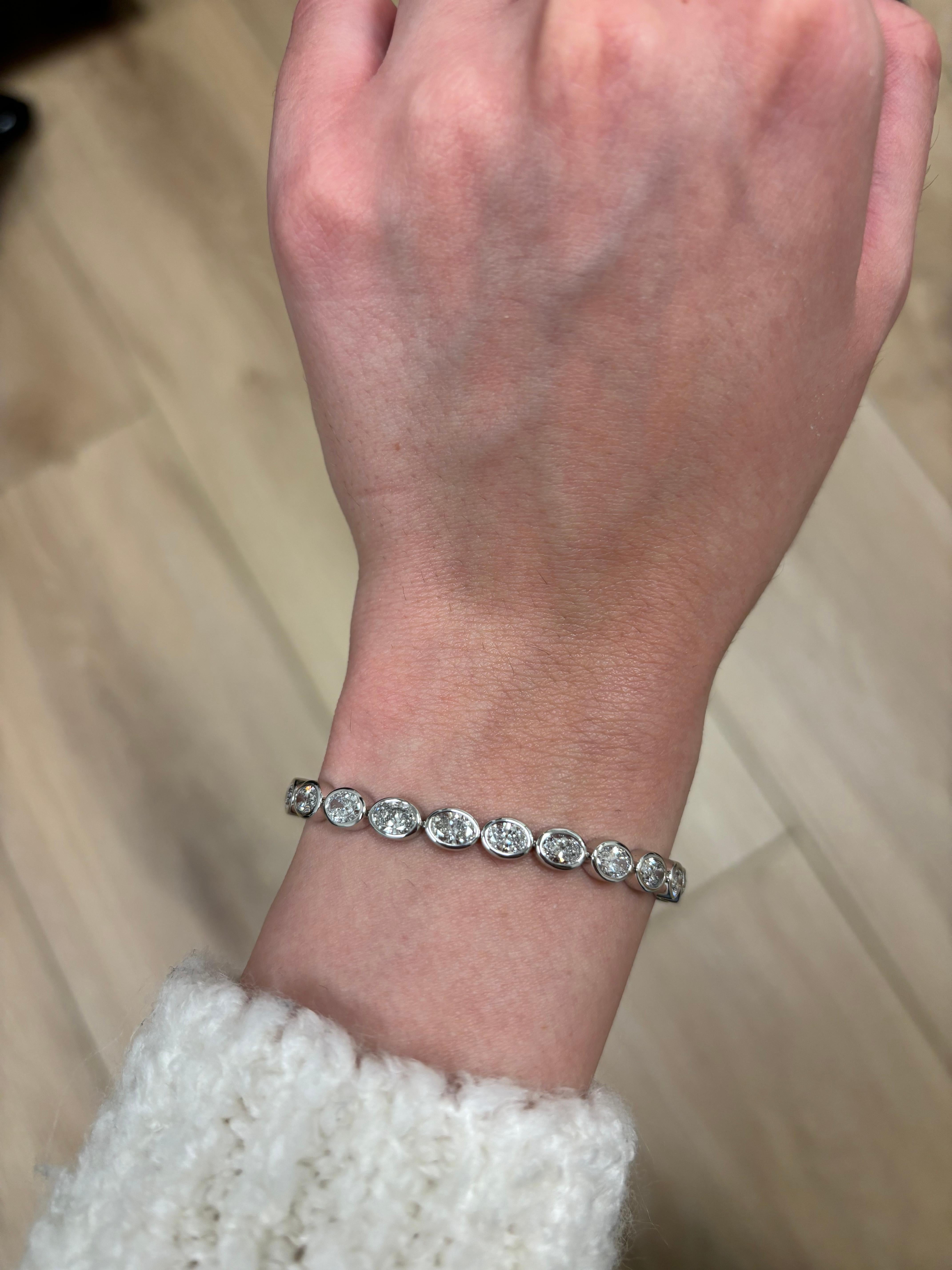 Stunning modern bezel set east-west oval cut diamond tennis bracelet. High jewelry by Alexander Beverly Hills.
27 oval cut diamonds, 8.46 carats. Approximately F/G color and SI clarity. 18k white gold, 14.87 grams, 7.25 inches.
Accommodated with an