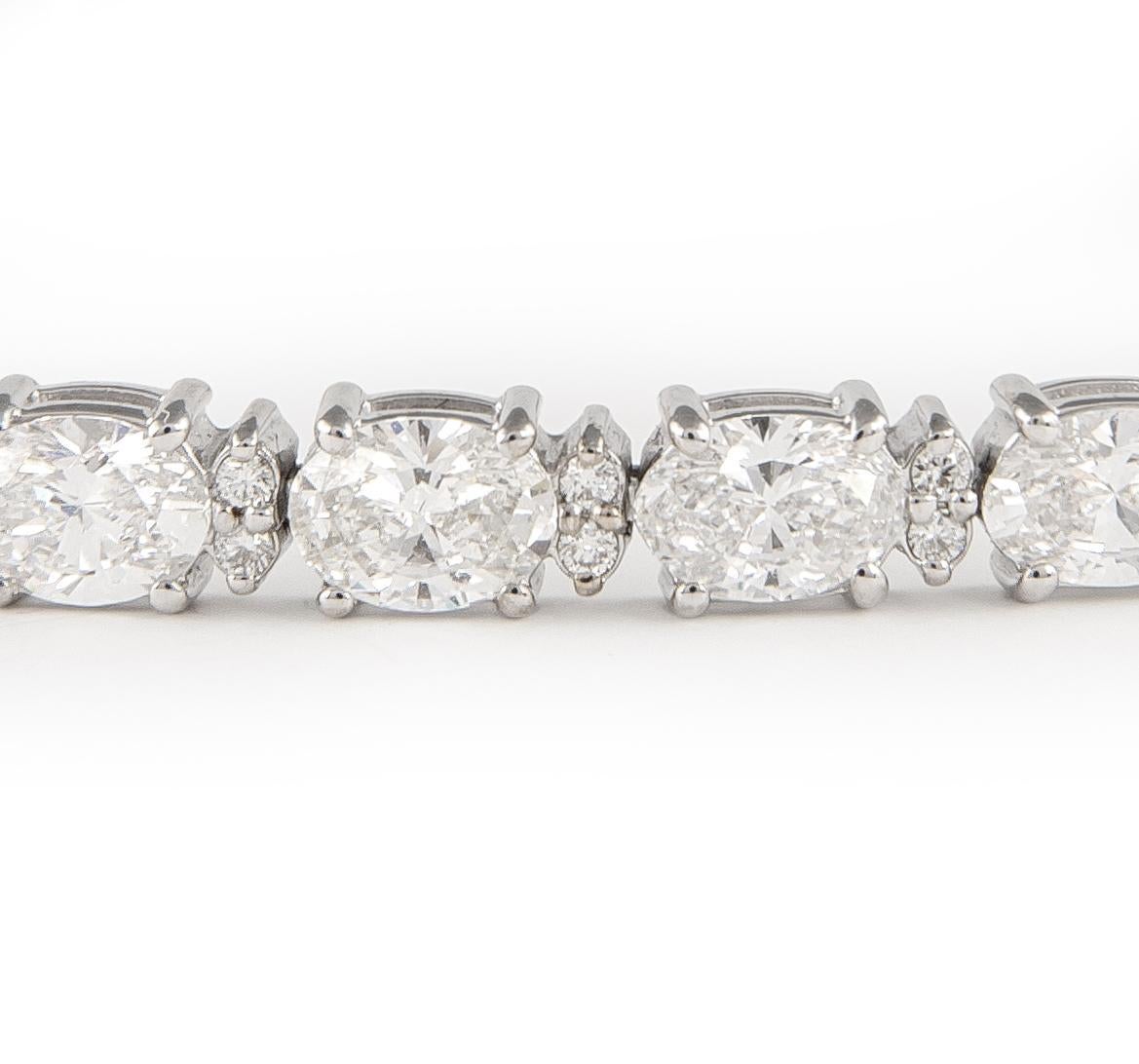 Splendido bracciale tennis moderno con diamanti taglio est-ovest e diamanti rotondi più piccoli. Alta gioielleria di Alexander Beverly Hills.
26 diamanti taglio ovale, 8,39 carati. Colore E e purezza VS1. Con 52 diamanti rotondi da 0,37 carati.