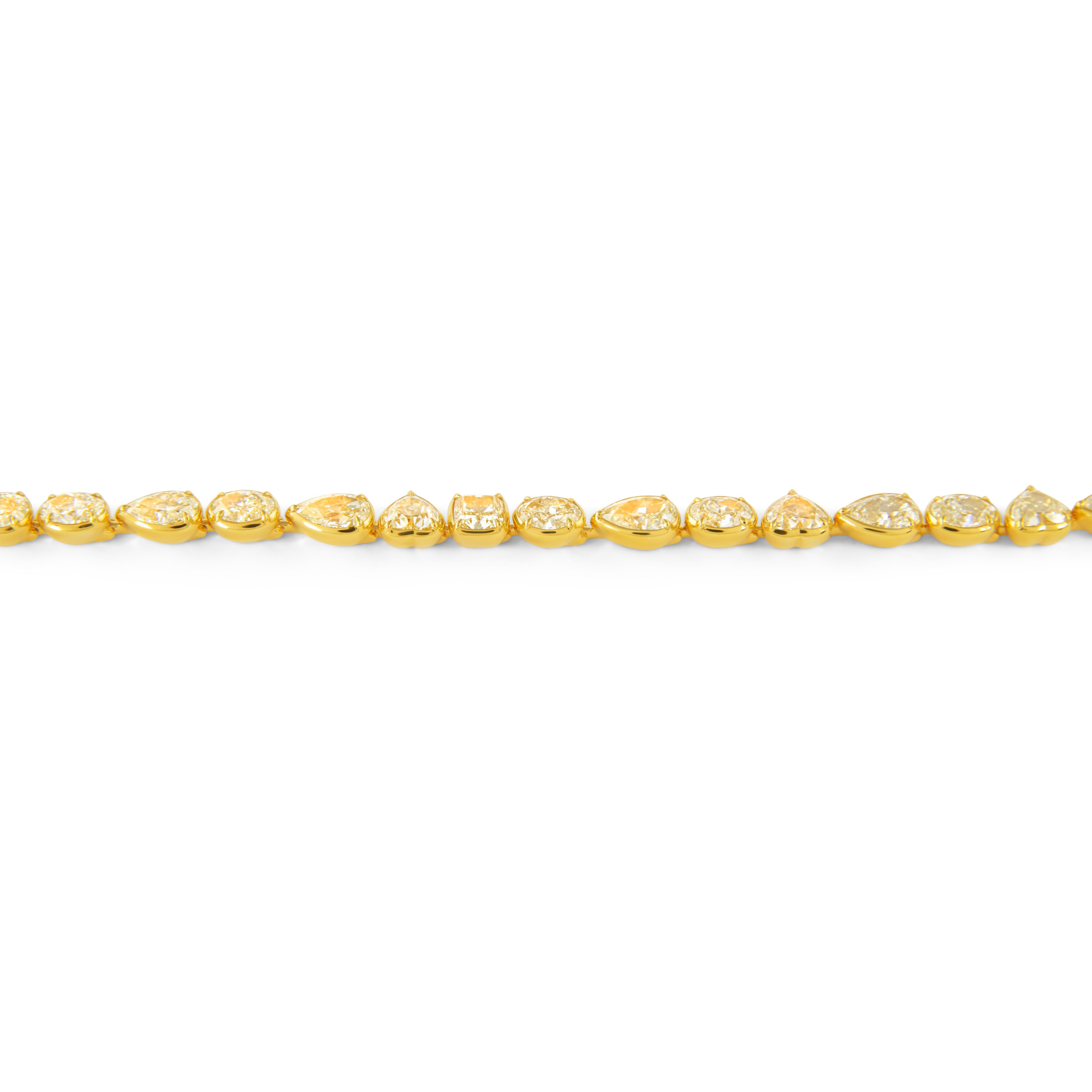Sensational modern alternating multi natural yellow diamond bezel set tennis bracelet, EGL certified. High jewelry by Alexander Beverly Hills.
21 oval, heart, pear, and cushion shape yellow diamonds, 21.75 carats (avg 1.03ct). Fancy-Fancy Light