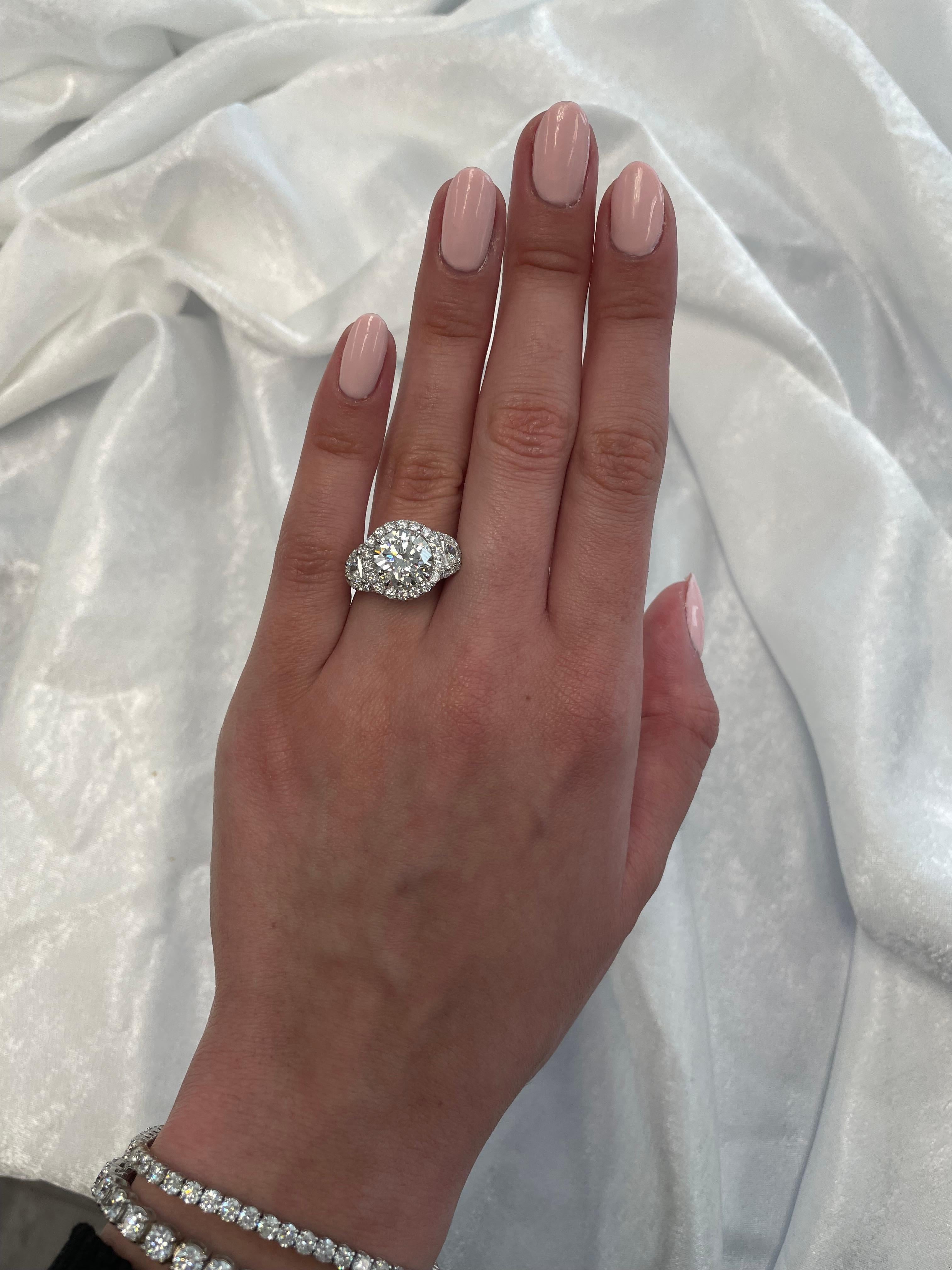 Splendido e classico anello di fidanzamento con tre pietre di diamante naturale e aureola, certificato EGL. Alta gioielleria di Alexander Beverly Hills.
4,33 carati di peso totale di diamanti.
Pietra centrale, diamante rotondo taglio brillante da