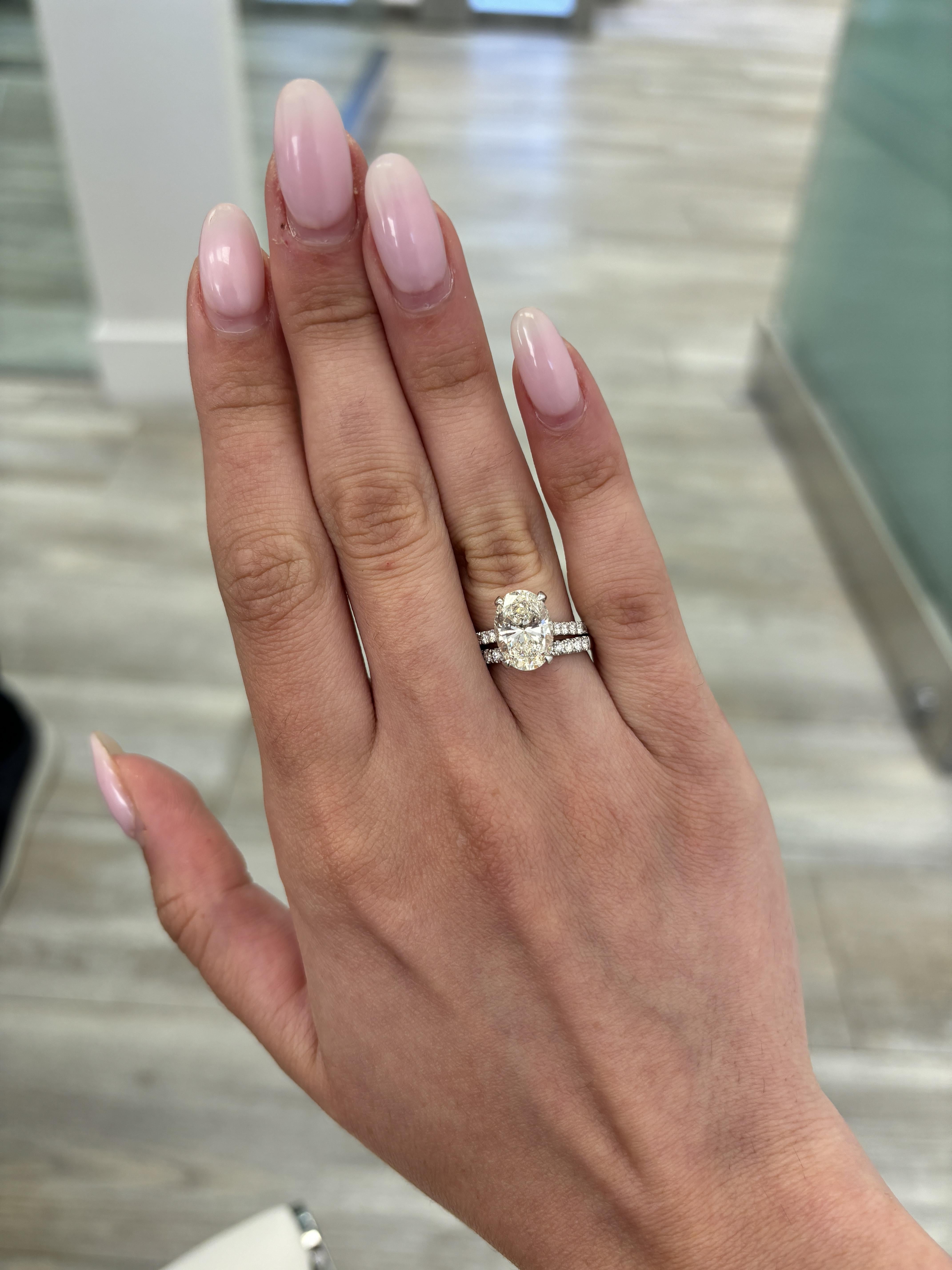 Classic solitaire with accent and hidden halo natural diamond engagement ring with half eternity band.
3.18 carat oval brilliant diamond. GIA certified J color grade and VS2 clarity grade. Complimented with 78 round diamonds, 0.93 carats.