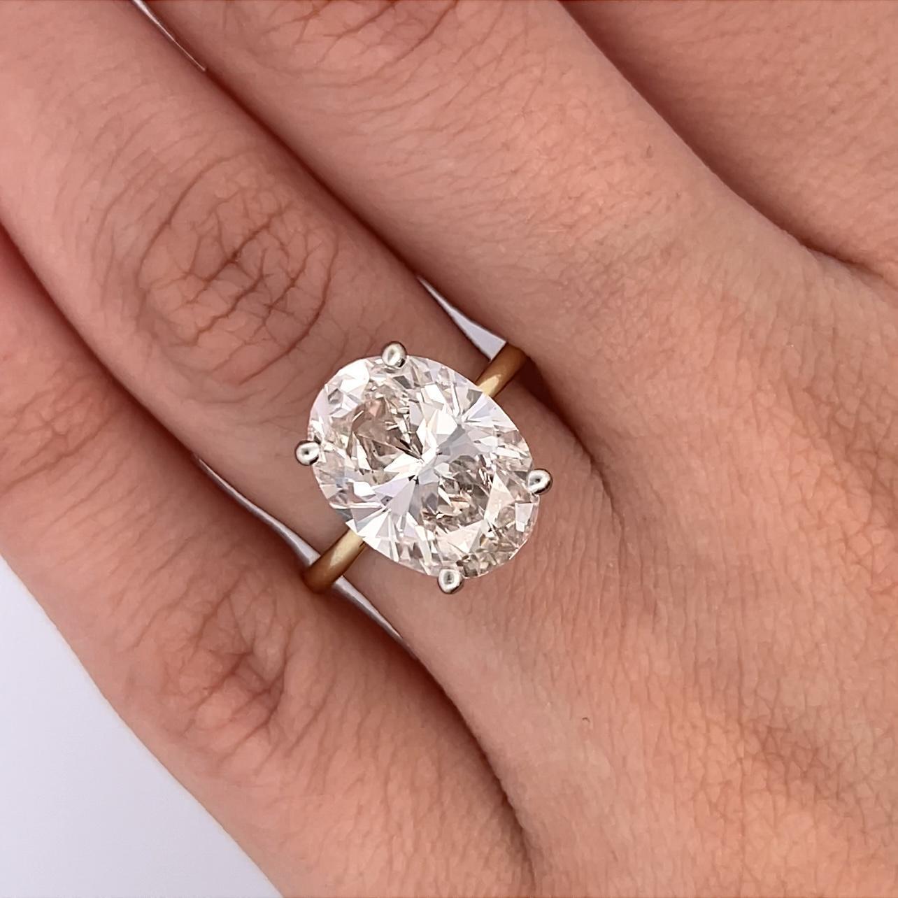 Stunning modern natural oval diamond solitaire engagement ring with hidden halo, GIA certified. High jewelry by Alexander Beverly Hills
GIA certified 5.18 carat oval cut diamond, J color grade, and SI1 clarity grade. 14K Yellow and white gold,
