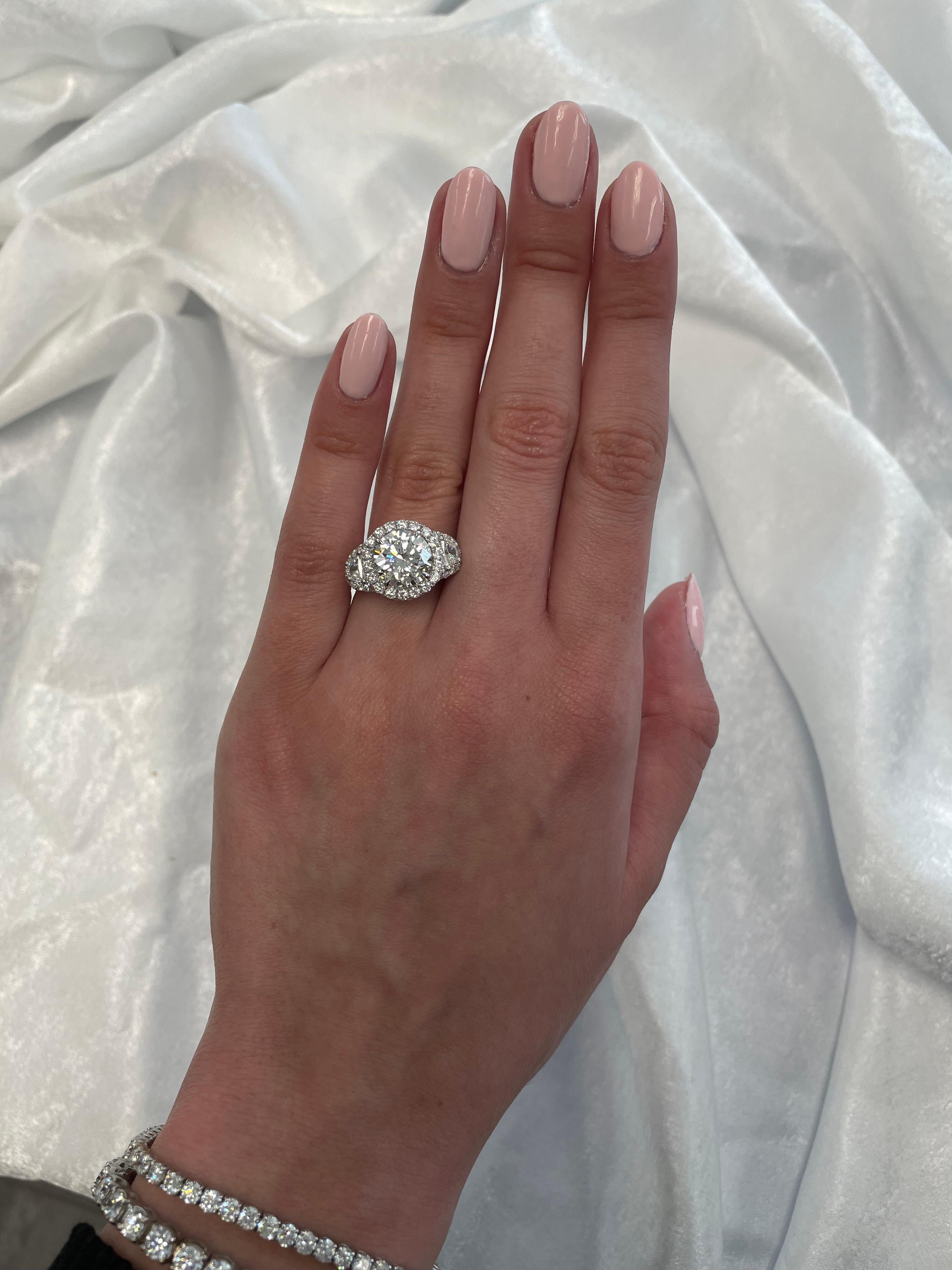 Stunning and classic diamond halo engagement ring, EGL certified. High jewelry by Alexander Beverly Hills.
Center stone, 3.05ct round brilliant cut diamond. I color grade, VS2 clarity grade, EGL certified. Side stones, 2 half mood diamonds, 0.41
