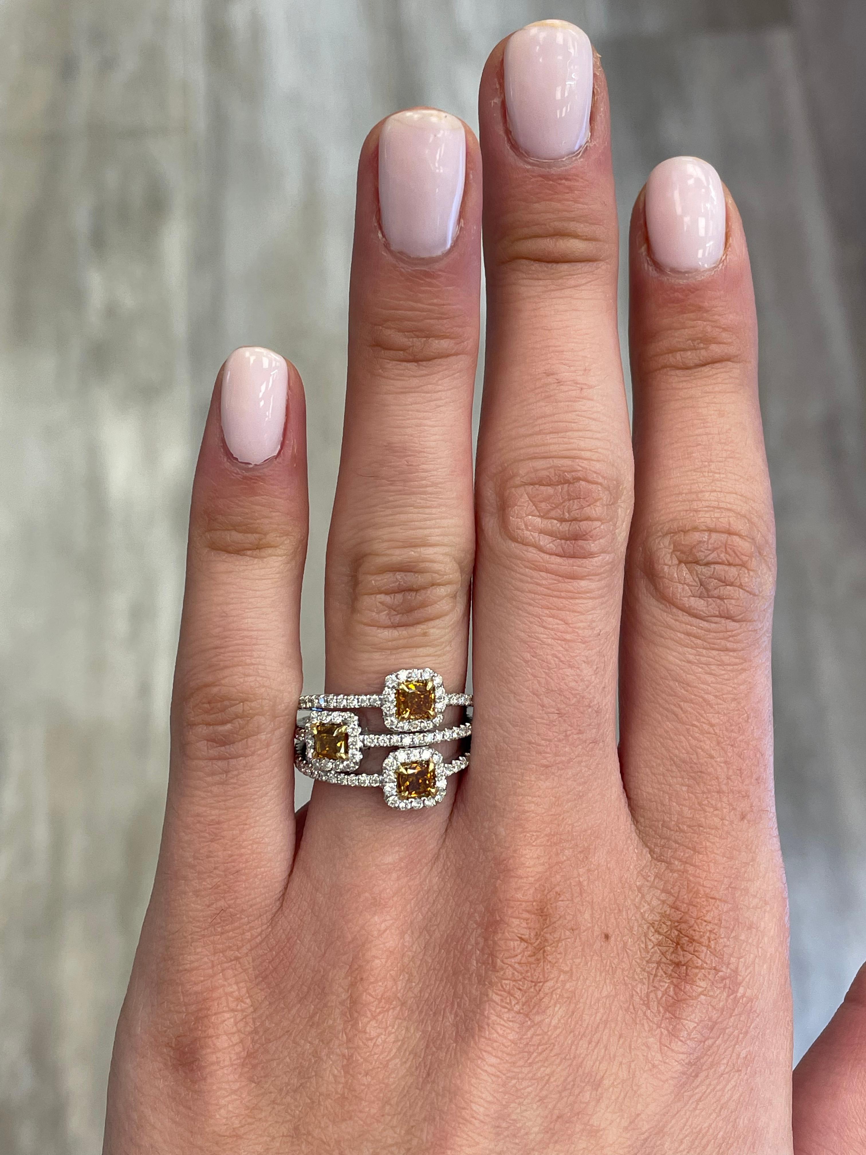 Stunning modern yellow diamond cocktail ring. High jewelry by Alexander Beverly Hills.
1.65 carats total diamond weight.
3 cushion diamonds, 1.01 carats. Approximately Fancy Intense Brownish Orangey Yellow color. Complimented by 105 round brilliant