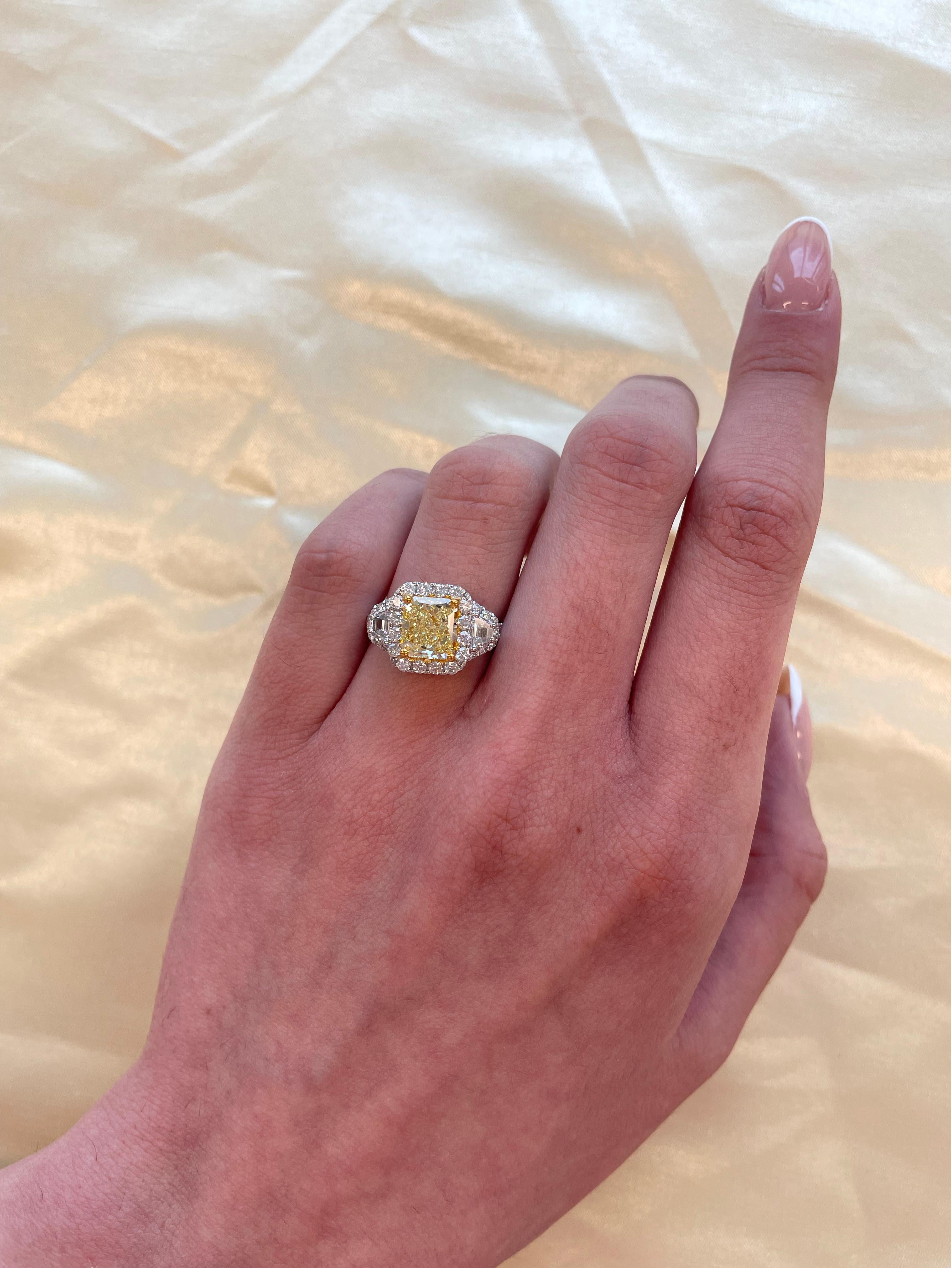 Stunning modern GIA certified fancy yellow diamond halo ring, two-tone 18k yellow and white gold. High jewelry by Alexander Beverly Hills.
*Center stone looks like a Fancy Intense Yellow diamond in the mounting
2.96 carats total diamond weight.
2.02