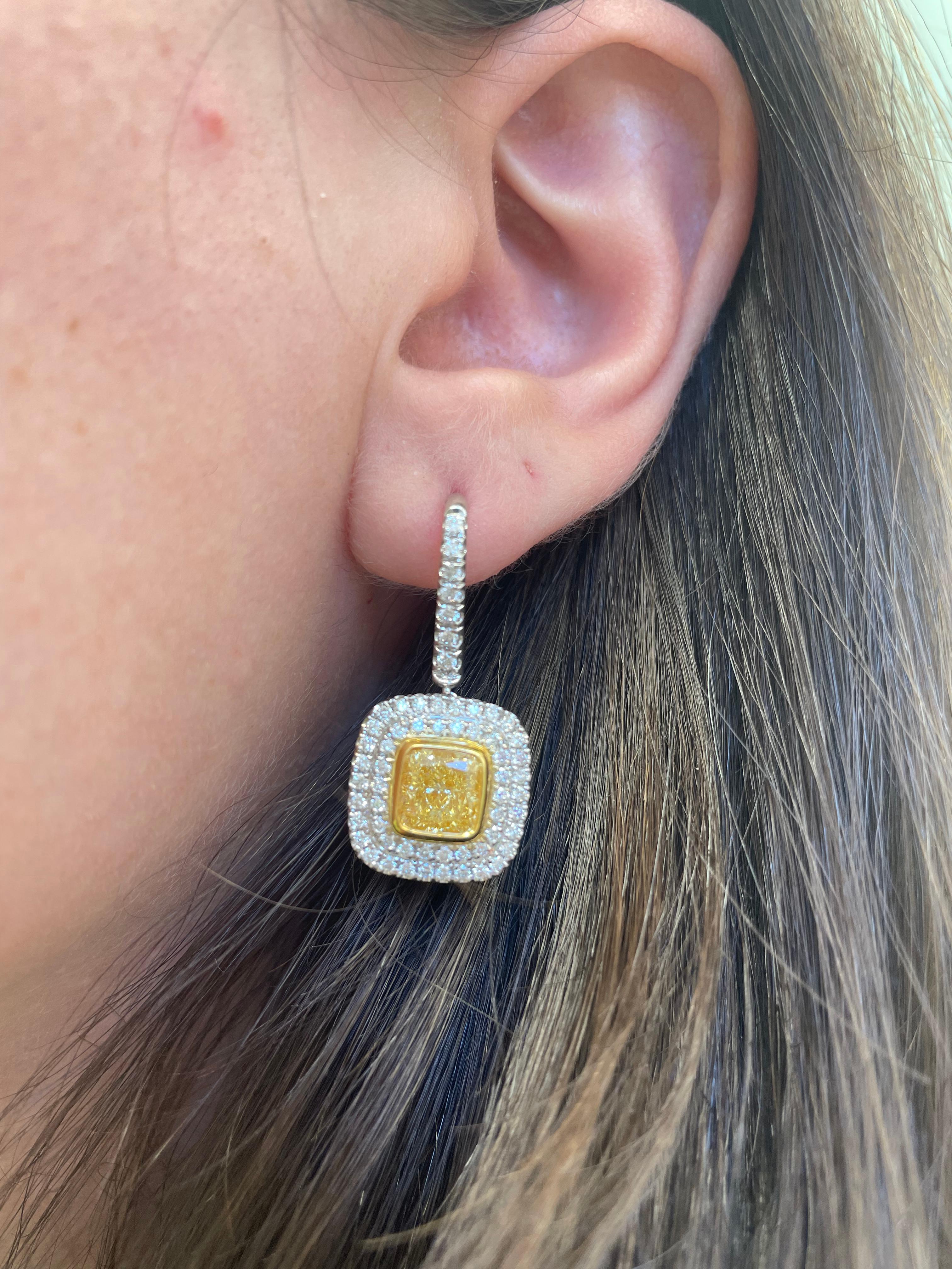 Stunning fancy yellow diamonds (that look fancy intense) with halo earrings, GIA certified. High jewelry by Alexander Beverly Hills. 
5.45 carats total diamond weight. 
*Center stones look Fancy Intense Yellow in the mounting 
2 cushion cut
