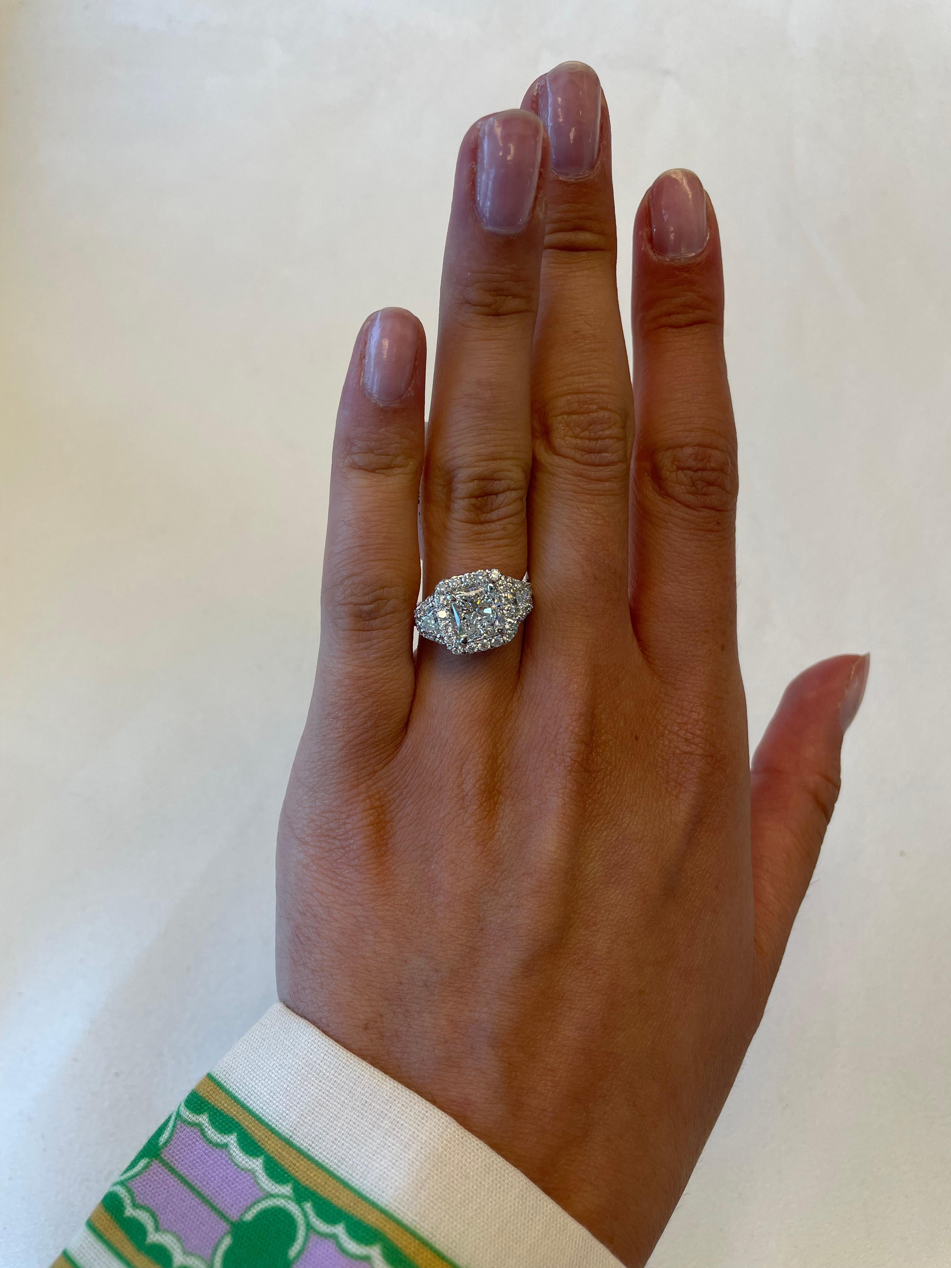 Stunning diamond three-stone engagement ring with halo, GIA certified. By Alexander Beverly Hills.
3.06 carats total diamond weight.
2.00 carat radiant cut diamond, GIA certified. G color grade and VS1 clarity. Complimented by 2 trapezoids and 54
