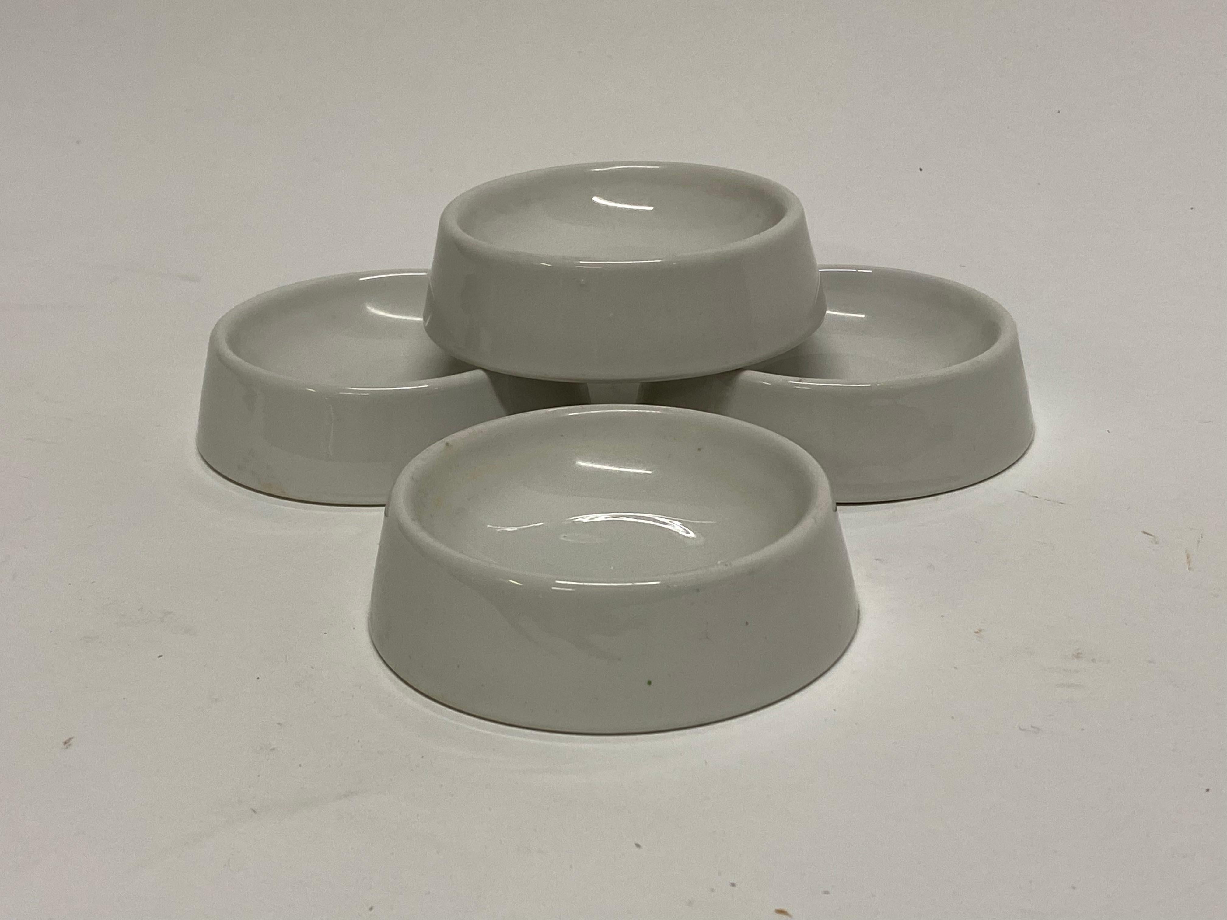 A set of four Alexander Girard designed white glazed porcelain bowls for Mayer China. A La Fonda Del Sol design. Fully signed on the bottom, A La Fonda Del Sol Design, Mayer China-Minners, 4 S Inc. Girard's iconic furniture, textile and decorative