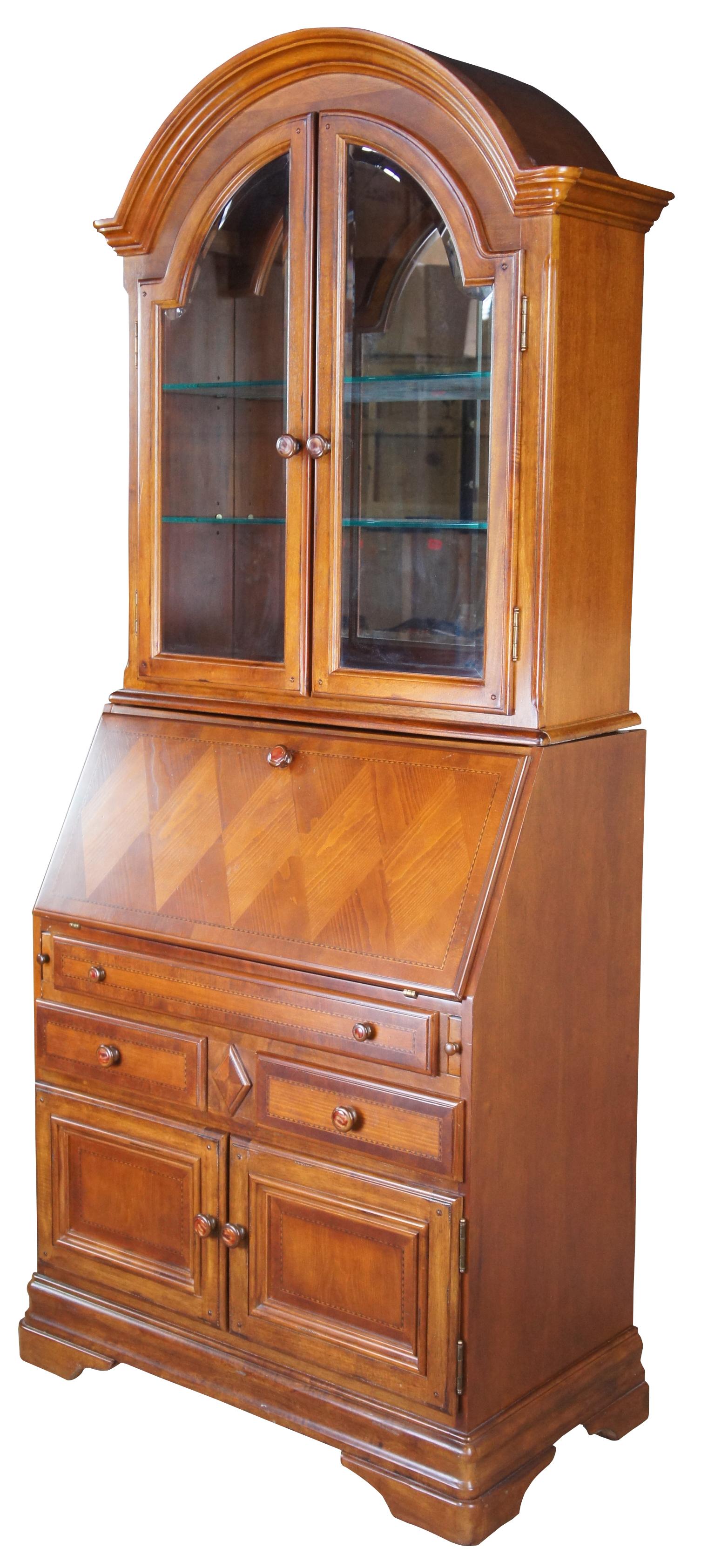 Vintage Alexander Julian Home Colours secretary desk cabinet. Made of cherry featuring an arched or domed top, mirrored back, two adjustable glass shelves, and beveled glass door fronts. The base cabinet features a drop front secretary with diamond