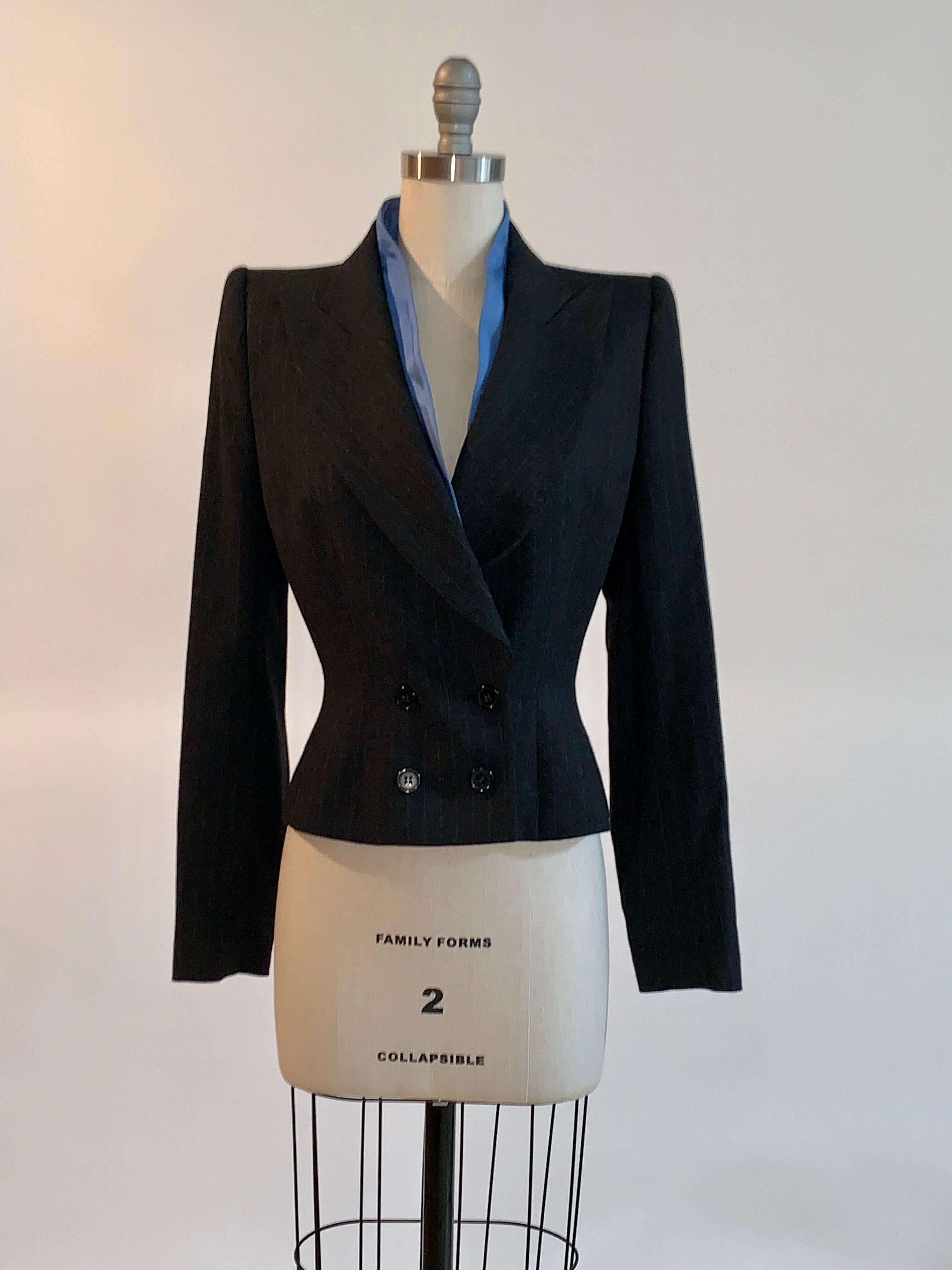 Alexander McQueen vintage 1990s charcoal grey (close to black) and blue pinstripe blazer. Structured padded shoulders, silk trim peeks out around collar. Buttons at front, three buttons at each cuff. As seen in Look 20 of McQueen's Fall 1997 runway