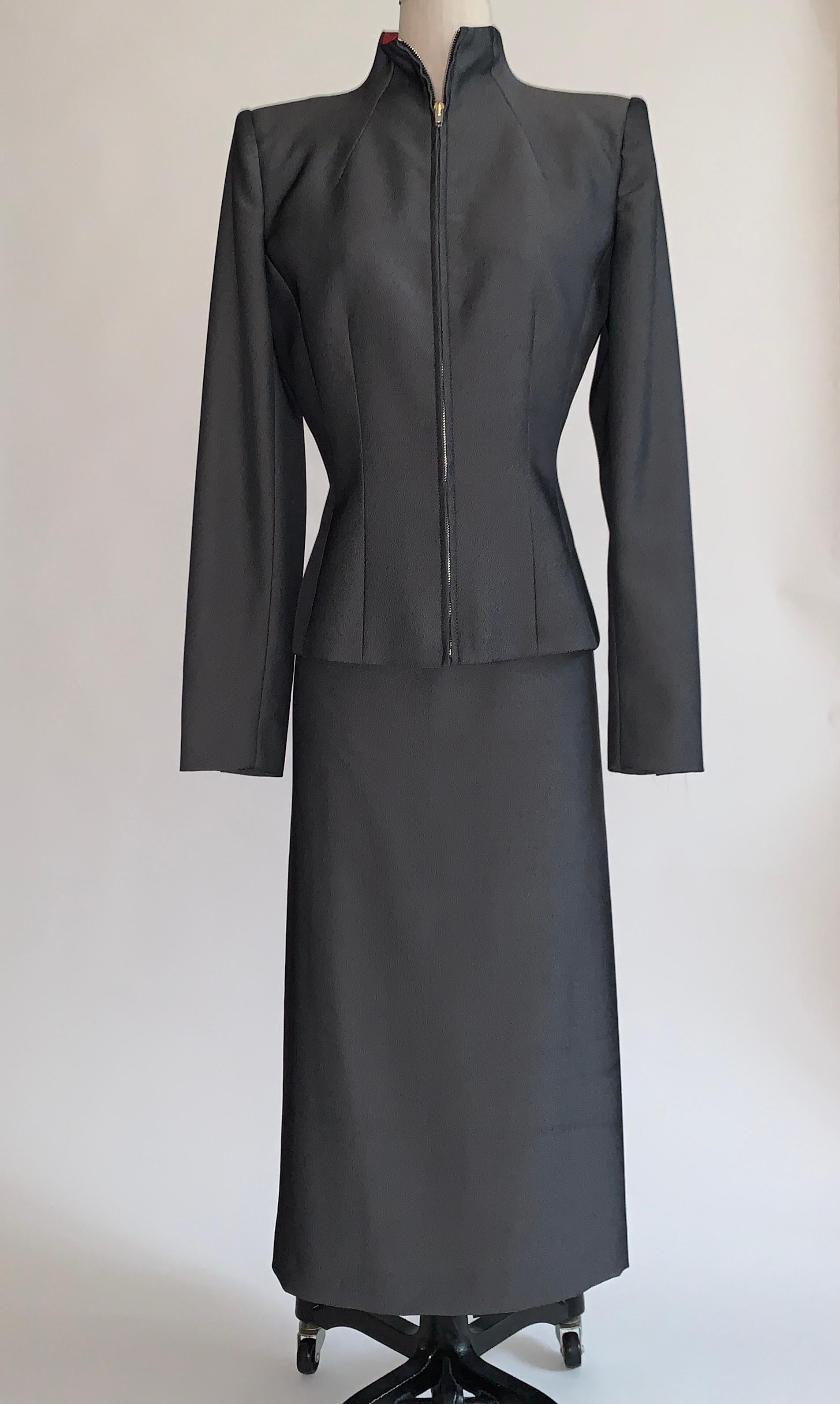 Vintage 1990s Alexander Mcqueen grey skirt suit from the 1998 Joan collection. Suit is made of a beautiful grey and black fabric with a light sheen. Amazingly tailored jacket has zippered front and light padding at shoulders for shape. Midi length