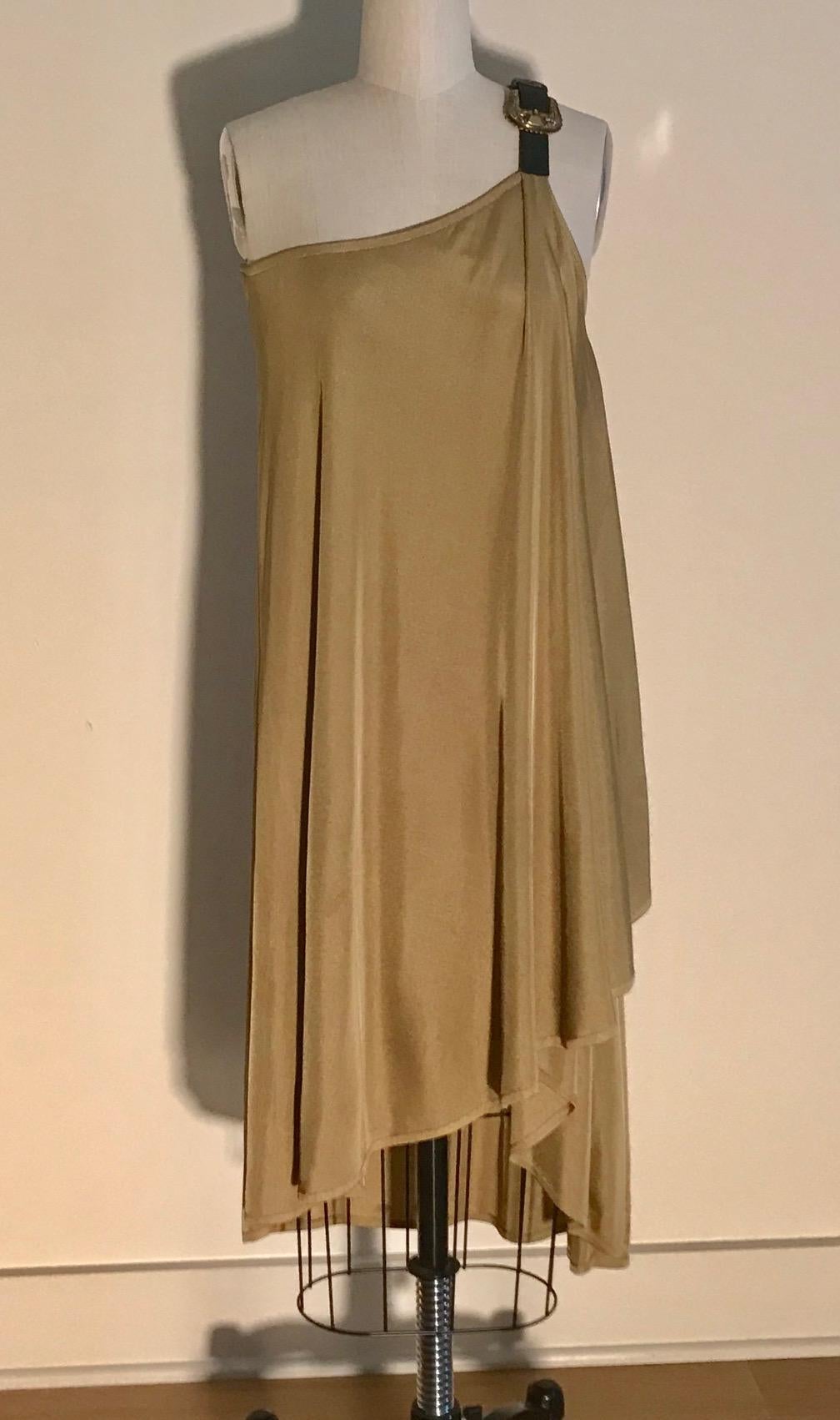 Alexander McQueen 2000s tan knit dress with leather strap at asymmetrical top and engraved gold buckle accent.

100% viscose, 100% leather strap.

Made in Italy.

Size Small.
Bust 30.
Waist open.
Hip open.
Length (top of strap to longest point of