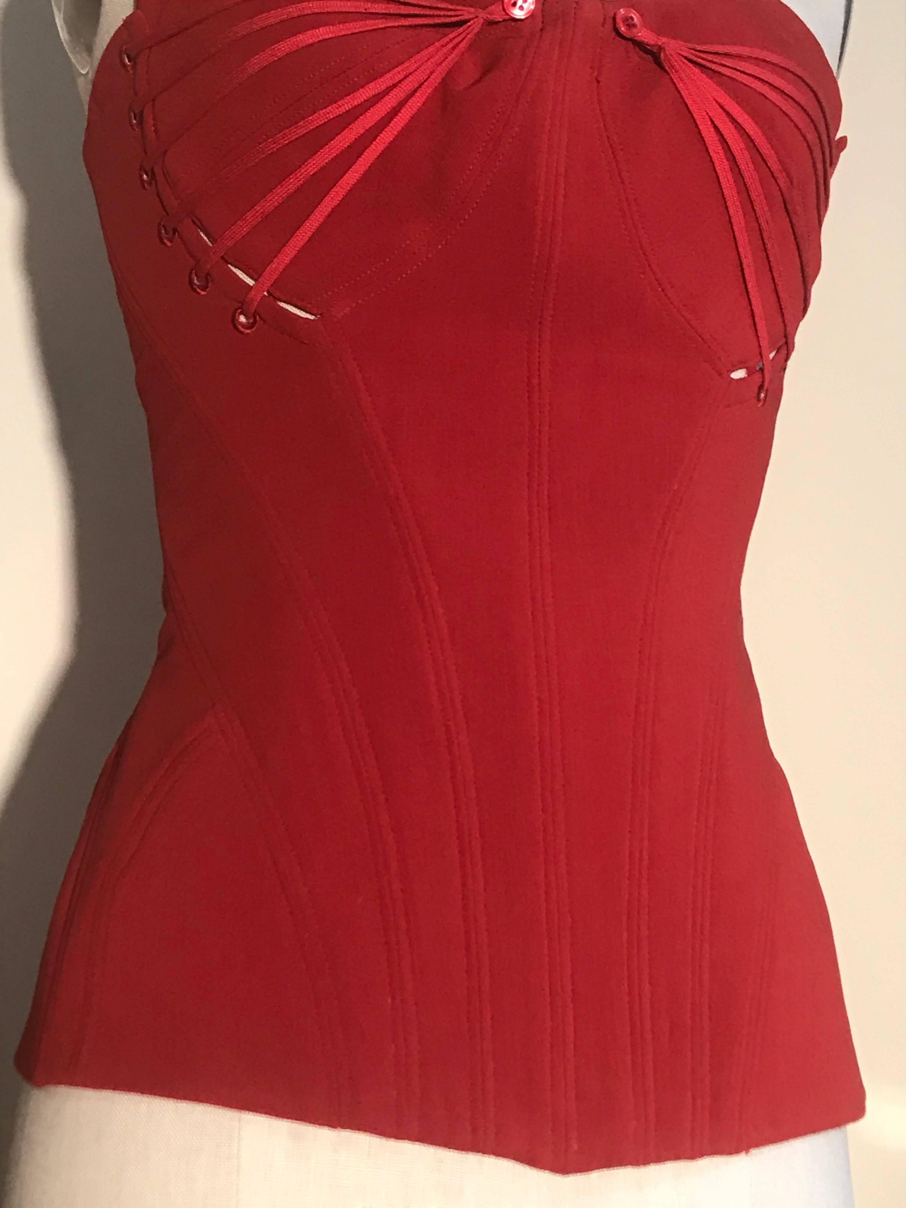 Alexander McQueen red corset top with elastic detailing at bust. Seam detailing and boning at interior. Zips at back and then laces up over the zipper. 

As seen in white on the Spring 2002 runway in look 17.

59% wool, 28% rayon, 8% polyamide, 5%