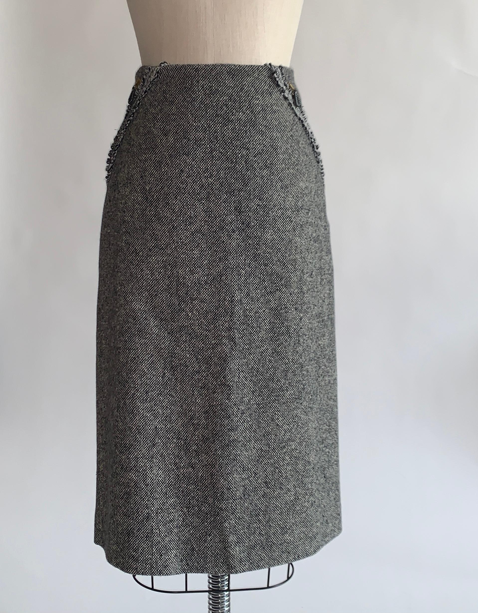 Alexander McQueen 2003 skirt in black and white tweed (reads a little grey to the eye.) . Back zip and hook and eye. Gold tone zips with leather tabs run alongside black and white trim from front waist to back hem. Zippers can unzip at bottom to