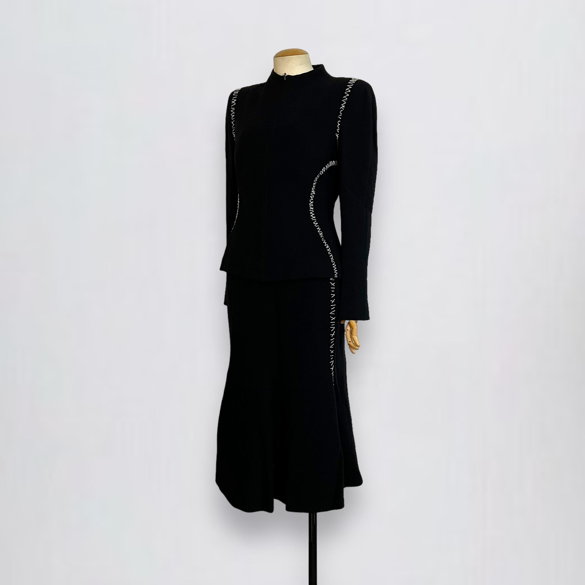 Cette veste Alexander McQueen est confectionnée en laine texturée noire, rehaussée de surpiqûres blanches distinctives pour un contraste saisissant. L'ensemble est accompagné d'une jupe assortie. Il est doté d'une fermeture à glissière sur le devant