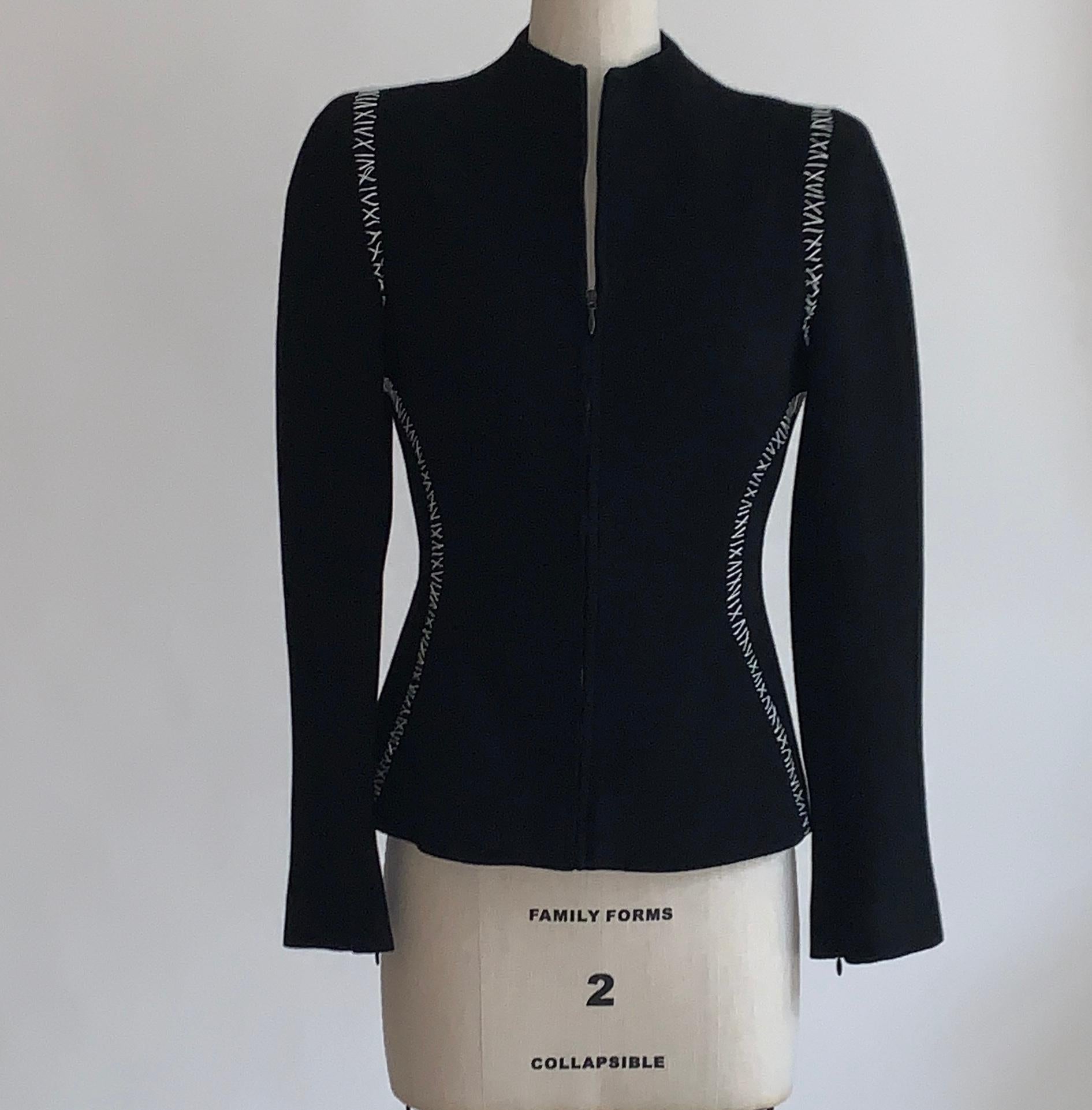 Alexander McQueen black textured wool jacket with contrasting white stitch detail. Zip front. Mid-weight padding at shoulders enhances structured silhouette, while zippers at cuff create an extra tailored sleeve. Chain at interior bottom hem