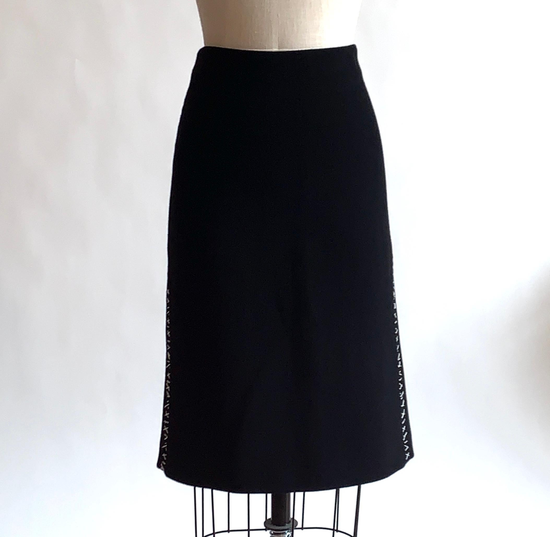 Alexander McQueen 2004 black pencil skirt with white accent stitches at back and sides.  Zip and hook and eye  at back waist, slit at back center. (Main photo is side view.)

100% wool.
Fully lined.

Made in Italy.

Size Italian 40, approximate US