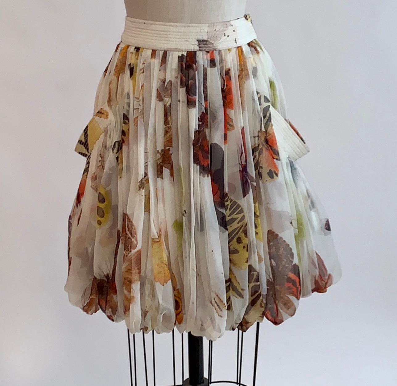 Alexander McQueen 2006 butterfly print silk chiffon skirt in shades of cream, yellow, orange, and brown. Seam detail at banded waist and at trim at top of side pockets. Bubble hem. Side zip and hook and eye. 

100% silk. 
Fully lined in 100%