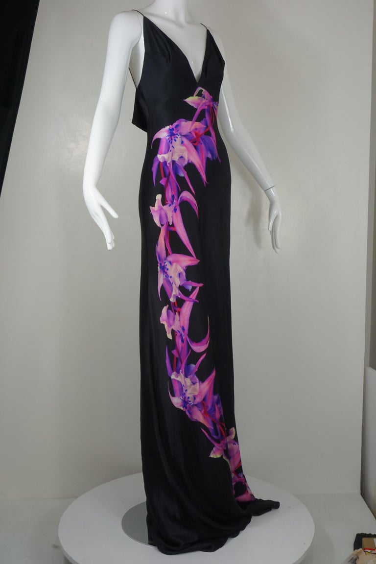 Alexander McQueen iconic black silk bias cut slip dress gown from his 2007 Collection is a beautiful example of his fascination with orchids. Gown is constructed from black silk charmeuse with a purple and pink orchid print down the front of the