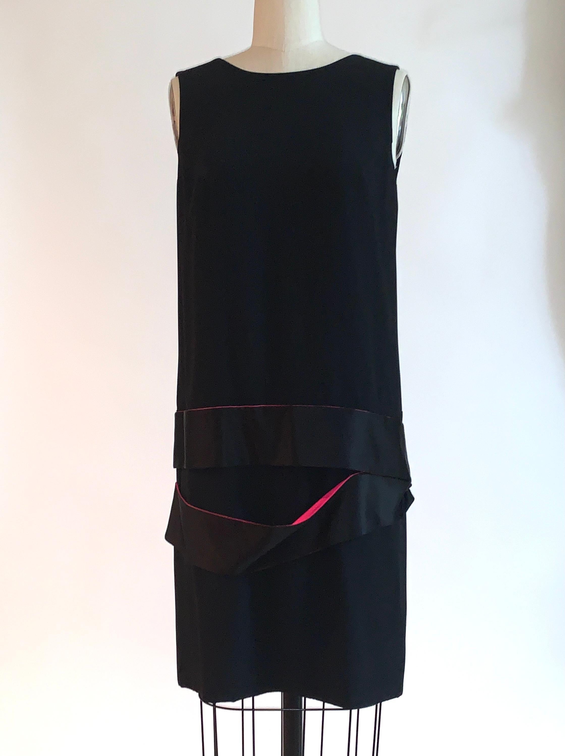 Alexander McQueen black sleeveless drop waist dress with deep v back and black and pink silk bands at dropped waist. From the 2008 collection created as a tribute to McQueen's mentor Isabella Blow. Back zip and hook and eye. 

48% acetate, 48%