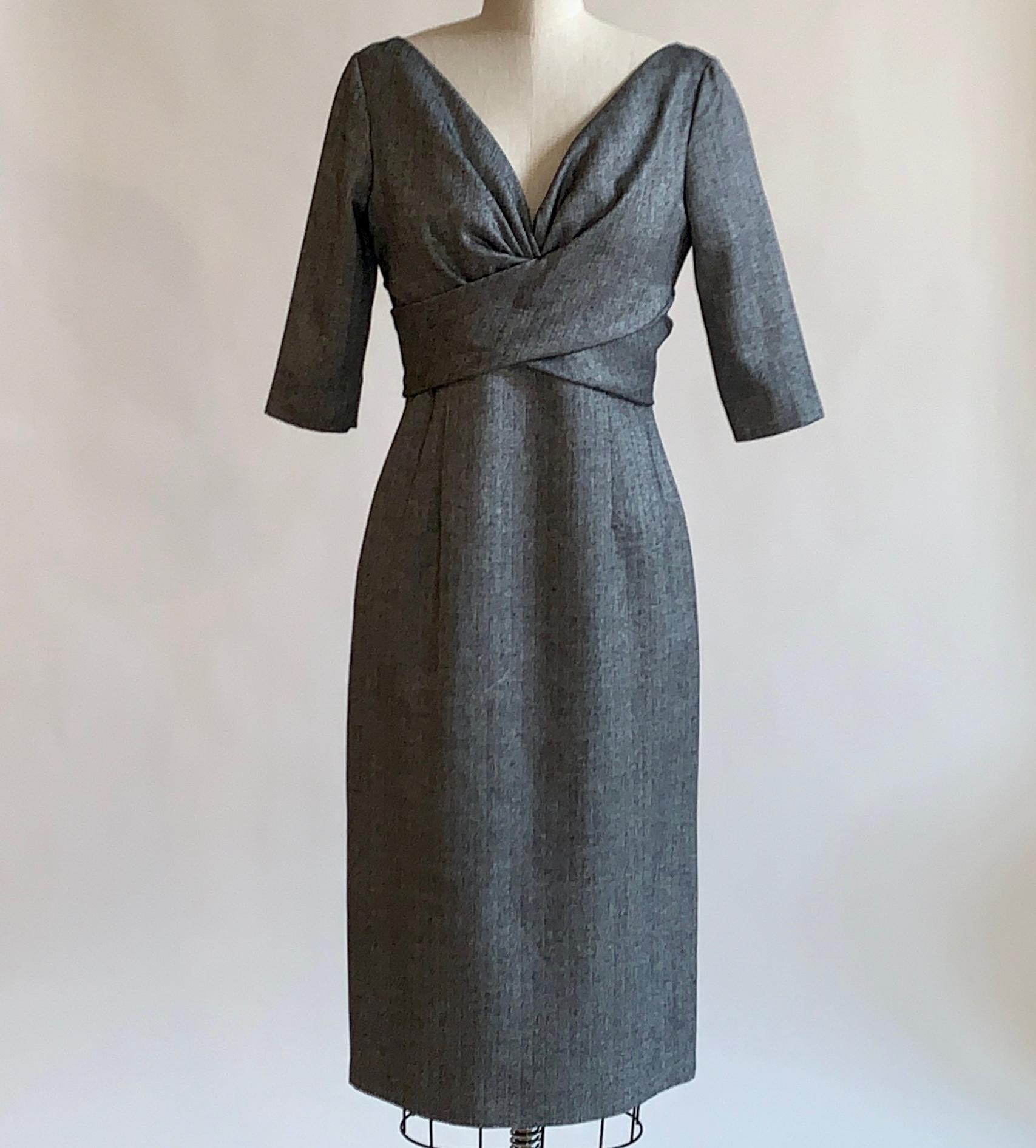 Alexander McQueen 2008 grey and black herringbone pencil dress with mid length sleeve, v neck, and  wrap-style detail at bust. Back zip and hook and loop closure.

50% virgin fleece wool, 45% bamboo, 5% cashmere.
Top lined in 50% virgin fleece wool,