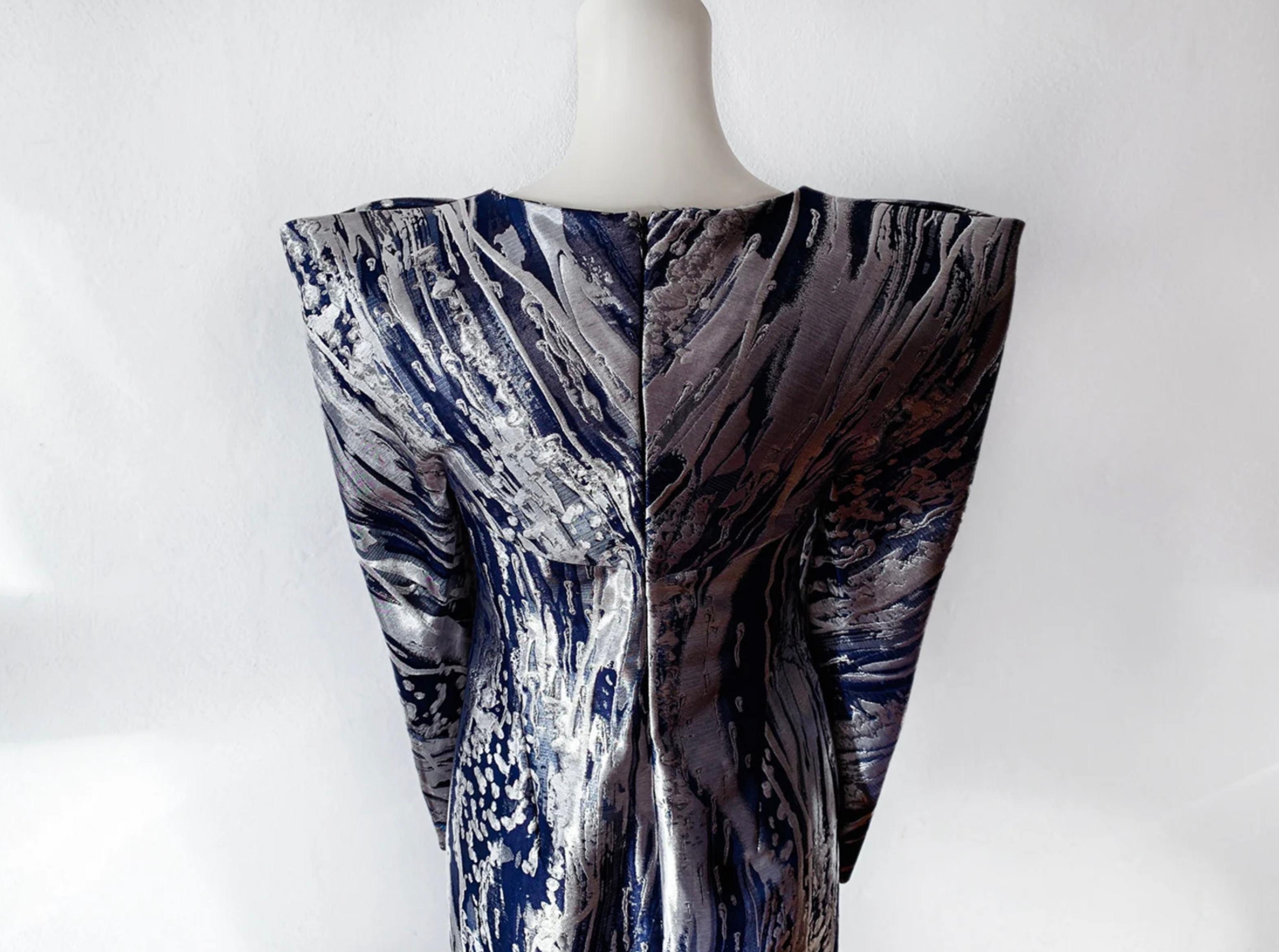 
Breathtaking Showstopper! Rare Collectors' Piece by the one and only Alexander McQueen.
Futuristic Avant Garde surreal dream and part of Fashion History.
Blue and silver metallic paint stroke brocade shift dress. The construction of this garment is