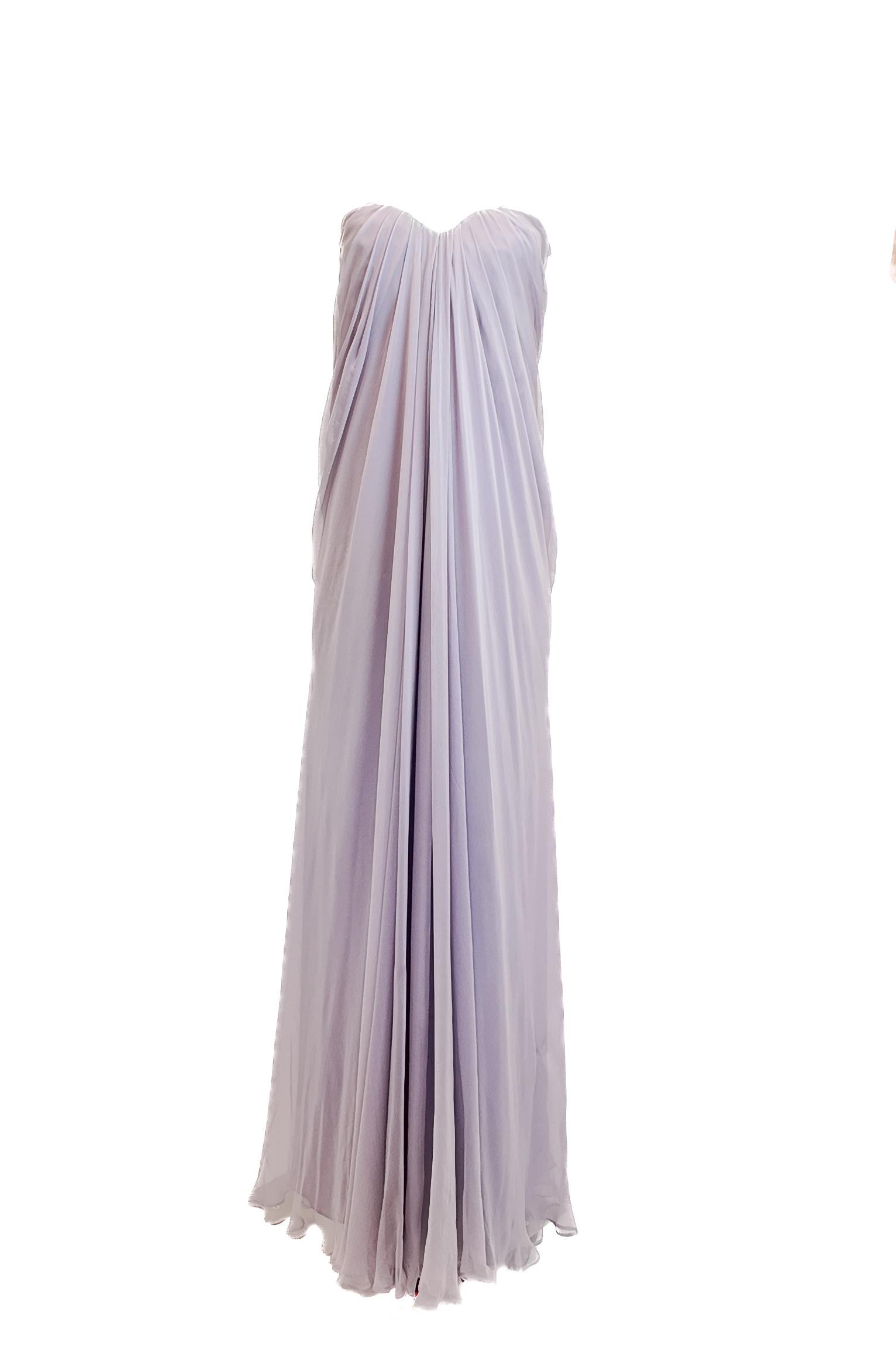 Dieses trägerlose Kleid von Alexander McQueen aus dem Jahr 2011 ist ein Beispiel für die meisterhafte Kombination aus ätherischer Eleganz und dramatischer Schnittführung des Hauses. Das Kleid aus fließendem, lavendelfarbenem Seidenchiffon verfügt