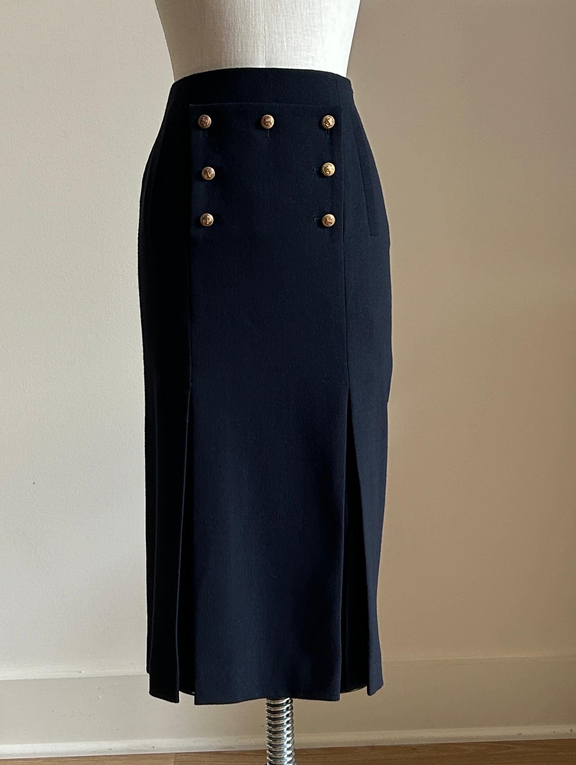 Alexander McQueen navy blue pencil skirt with gold anchor buttons from the Pre-Fall 2011 collection.

Faux broadtail flap at front fastened with 7 antiqued buttons. Faux slash/welt pockets at front. Layered pleat detail at two front slits. Side zip