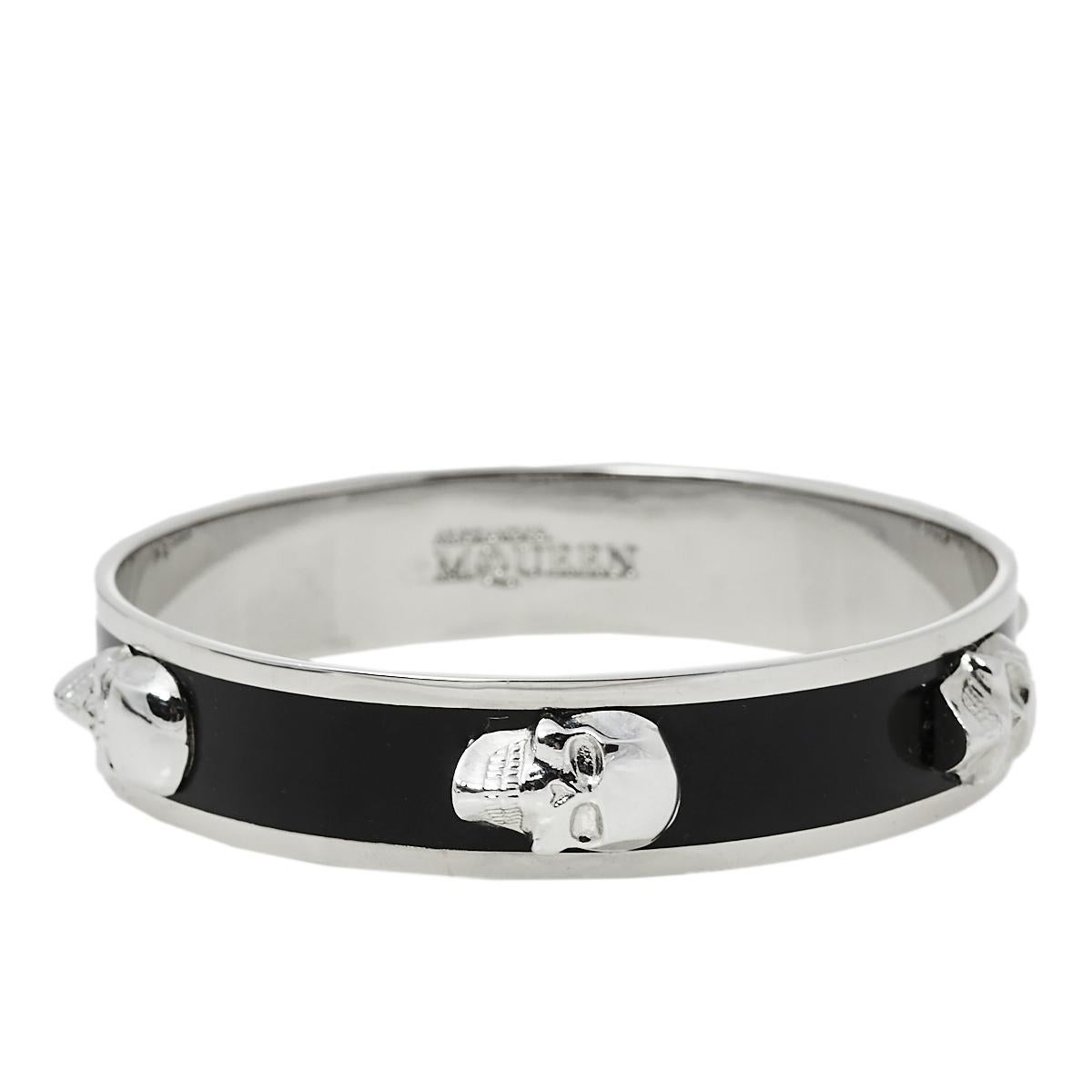 This bangle bracelet by Alexander McQueen holds a bold and distinguished appeal. Crafted from silver-tone metal, it is coated with black enamel all around. The bangle is highlighted with the signature 3D skull detailing.

Includes: Original Box,