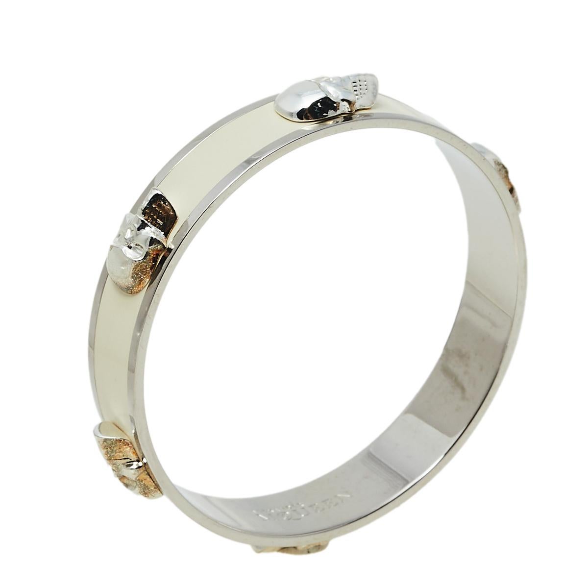 This bangle bracelet by Alexander McQueen holds a bold and distinguished appeal. Crafted from silver-tone metal, it is coated with white enamel all around. The bangle is highlighted with the signature 3D skull detailing.

Includes: Original Box
