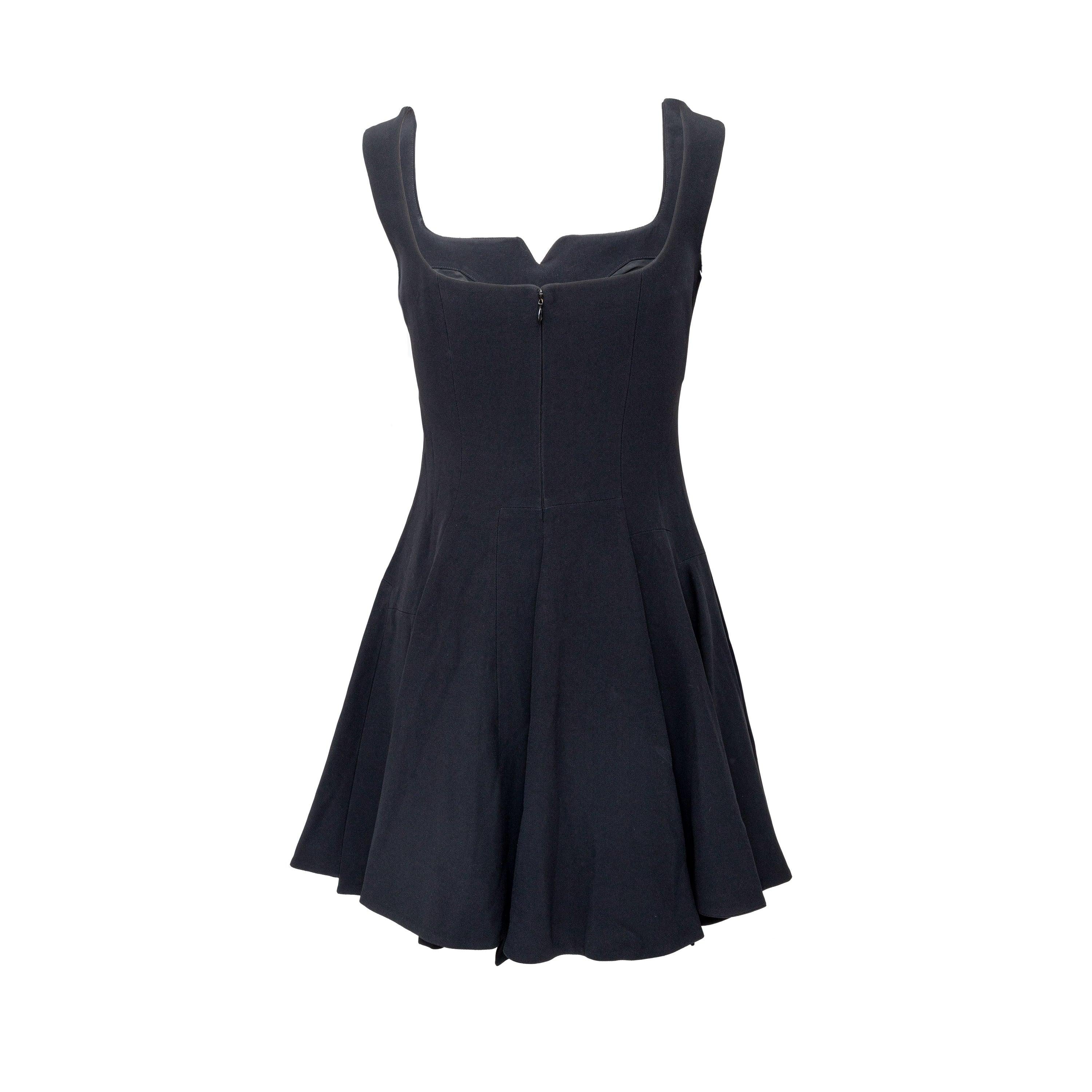 This chic little black dress by Alexander McQueen is crafted from an acetate blend crepe and features a notched square neckline, thin shoulder straps, and a scoop back. The dropped waist and flared A-line skirt with pleat lines create a flattering