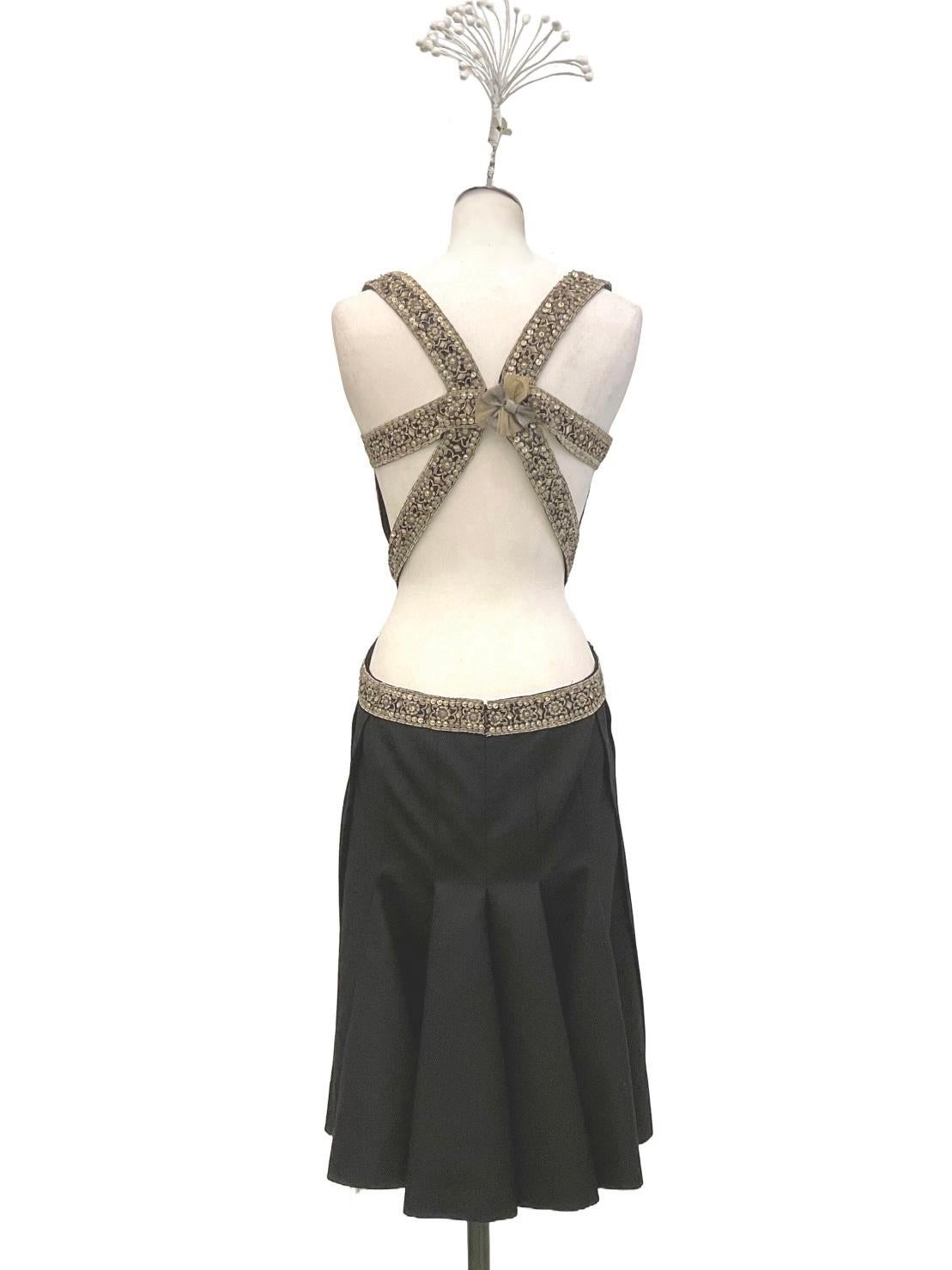 Black dress by Alexander McQueen from the Ready to Wear collection
Fall Winter 2003.
The petticoat neckline and straps, which continue with a crossover
on the back, are embellished with an appliquéd embroidered ribbon.
The embroidery of sequins,
