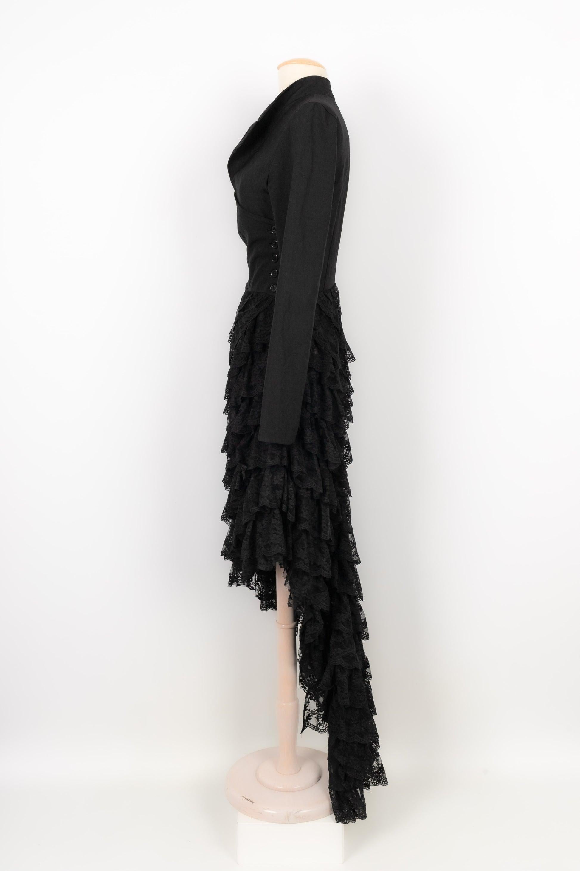 Alexander Mcqueen - (Made in Italy) Asymmetrical dress in black wool crepe and layered scalloped pleated lace. Row of buttons on the left side to the waist. Train style. No size label, it fits a 38FR. Spring-Summer 1999 Collection.

Additional