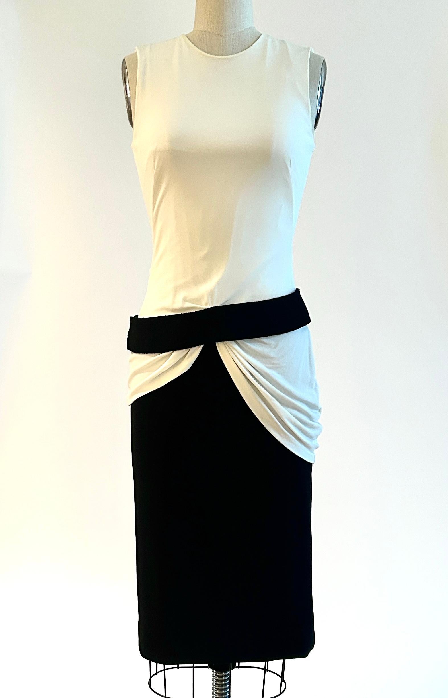Alexander McQueen sleeveless dress with white draped bodice and black bottom with attached belt at hip. Circa 2013. Below the knee length. Back zip and hook and eye with three snaps at belt. 

Fabric 1: 90% rayon, 10% elastane.
Fabric 2: 100%