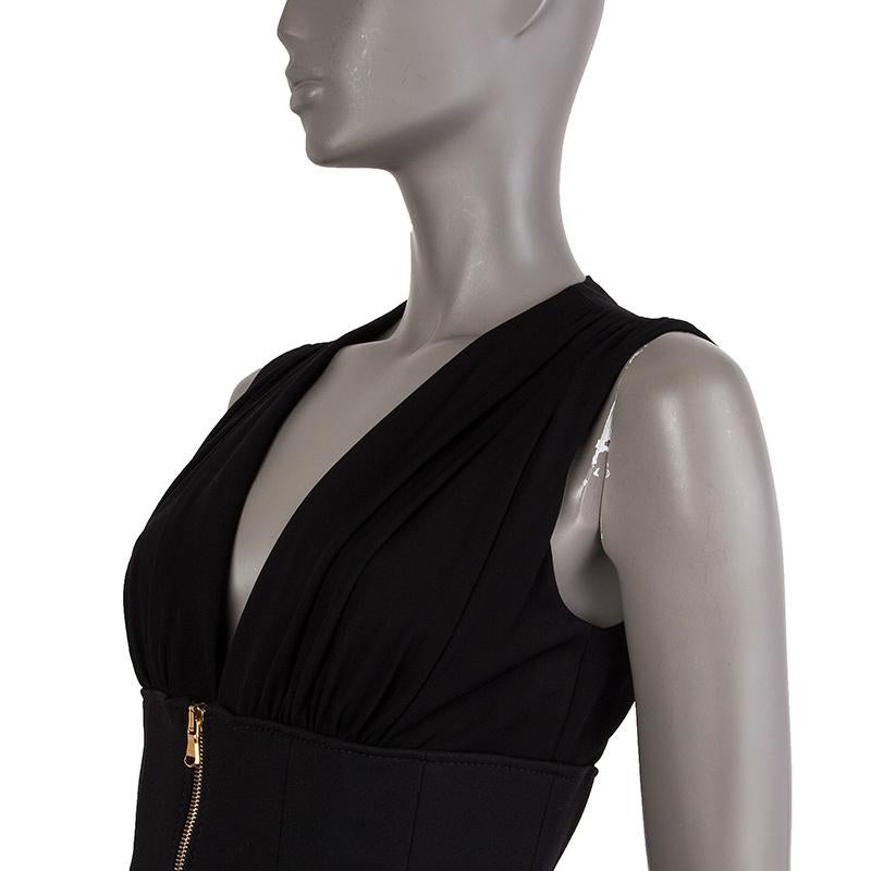 Alexander McQueen pleated dress in black rayon (100%). With low v neck and integrated corset on the outside. Closes with hook and invisible zipper on the back and corset closes with double-sided gold zipper on the front. Lined in black nylon (75%)