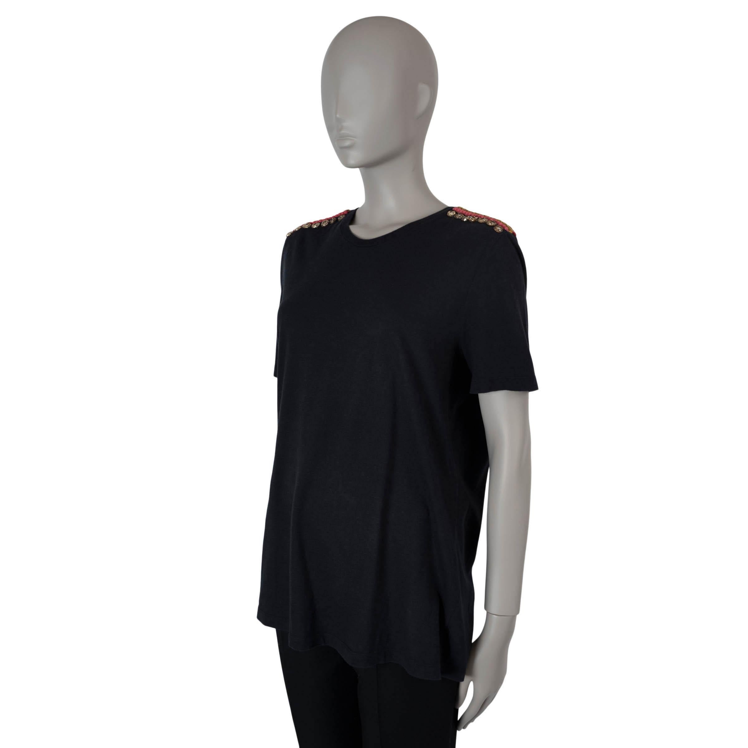 This 100% authentic Alexander McQueen T-shirt is crafted from black jersey cotton (100%) for a luxurious feel. It features a classic round neck and striking embroidered shoulder patches in red and gold, adorned with multicolored rhinestones. This