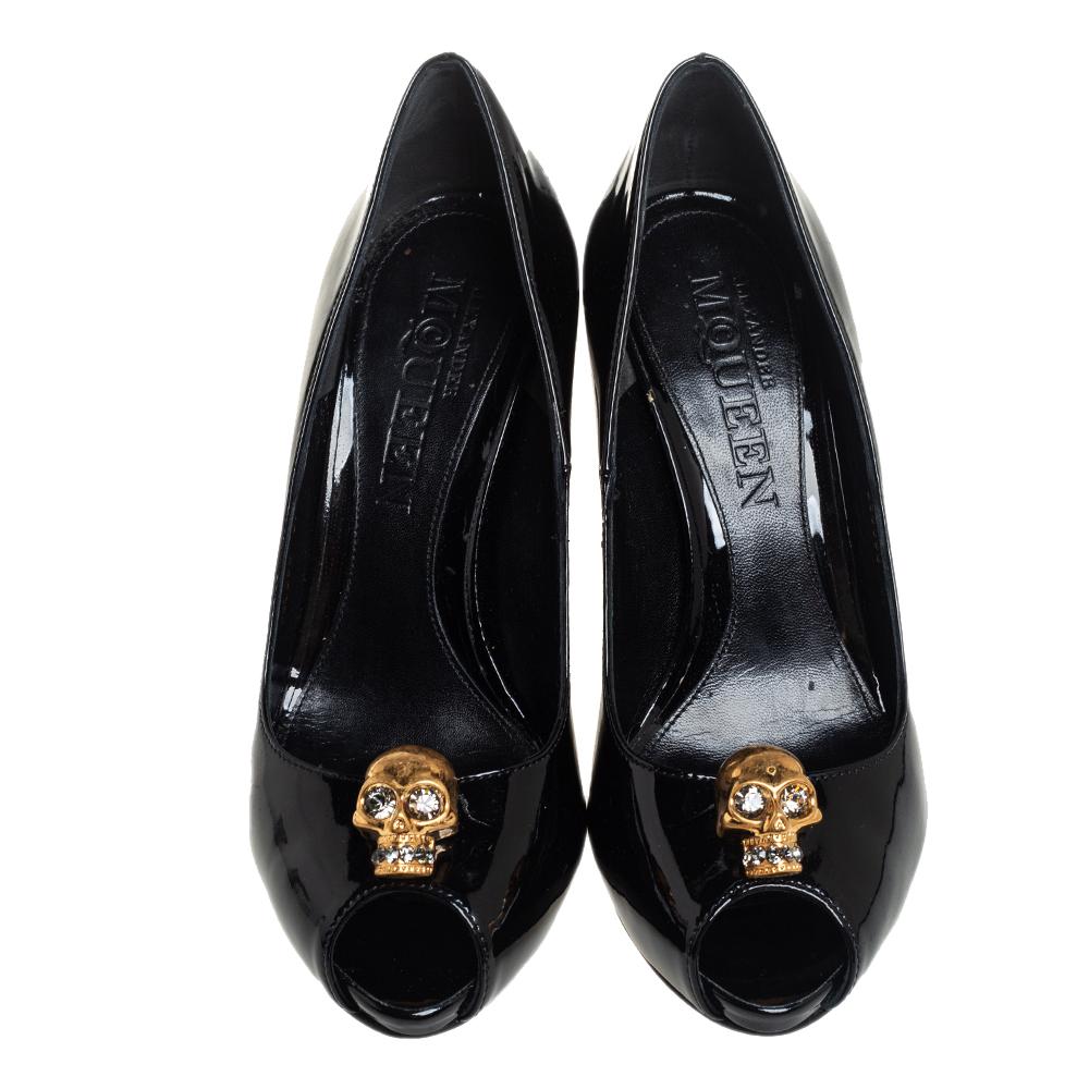 Breathtaking and whimsical, these pumps from Alexander McQueen are here to enchant you and make you fall in love with them. These black pumps are crafted from patent leather and feature a peep-toe silhouette. They flaunt a gold-tone