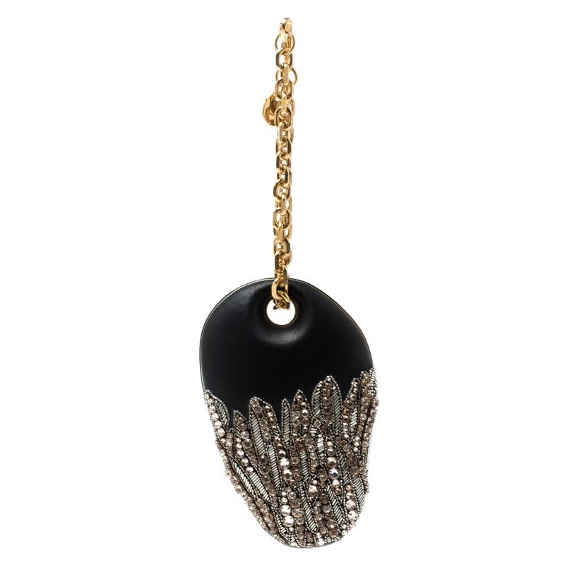 Shaped like a clam, this beautiful clutch by Alexander McQueen is bold and glamorous. It is rendered in black leather having a framed silhouette and is adorned beautifully with crystals and beads on the exterior. This exquisite clutch opens to a