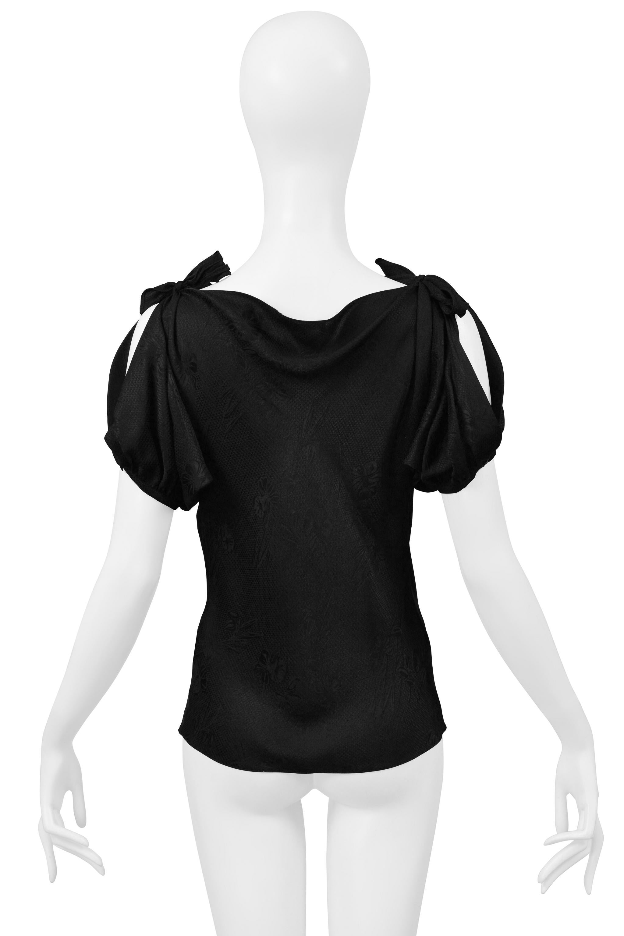 Resurrection Vintage is excited to offer a vintage Alexander McQueen black floral jacquard top featuring a cowl neckline, puff sleeves with shoulder ties, and a straight body. The shoulder ties can be worn as ties with knots or bows. 

* Alexander