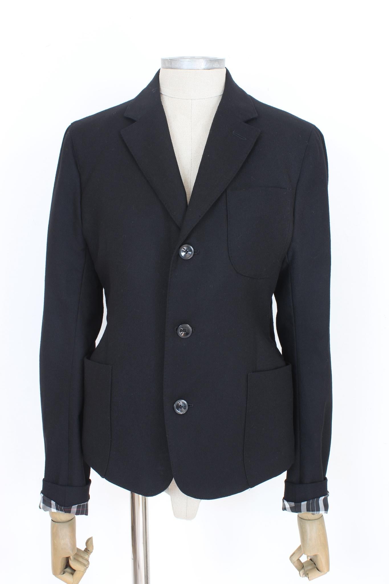 Featuring a sleek fitted design, this Alexander McQueen black wool jacket from the 2000s boasts a unique gold-colored zip running along the entire back. Composed of high-quality wool, this black blazer is a standout piece with a subtle touch of