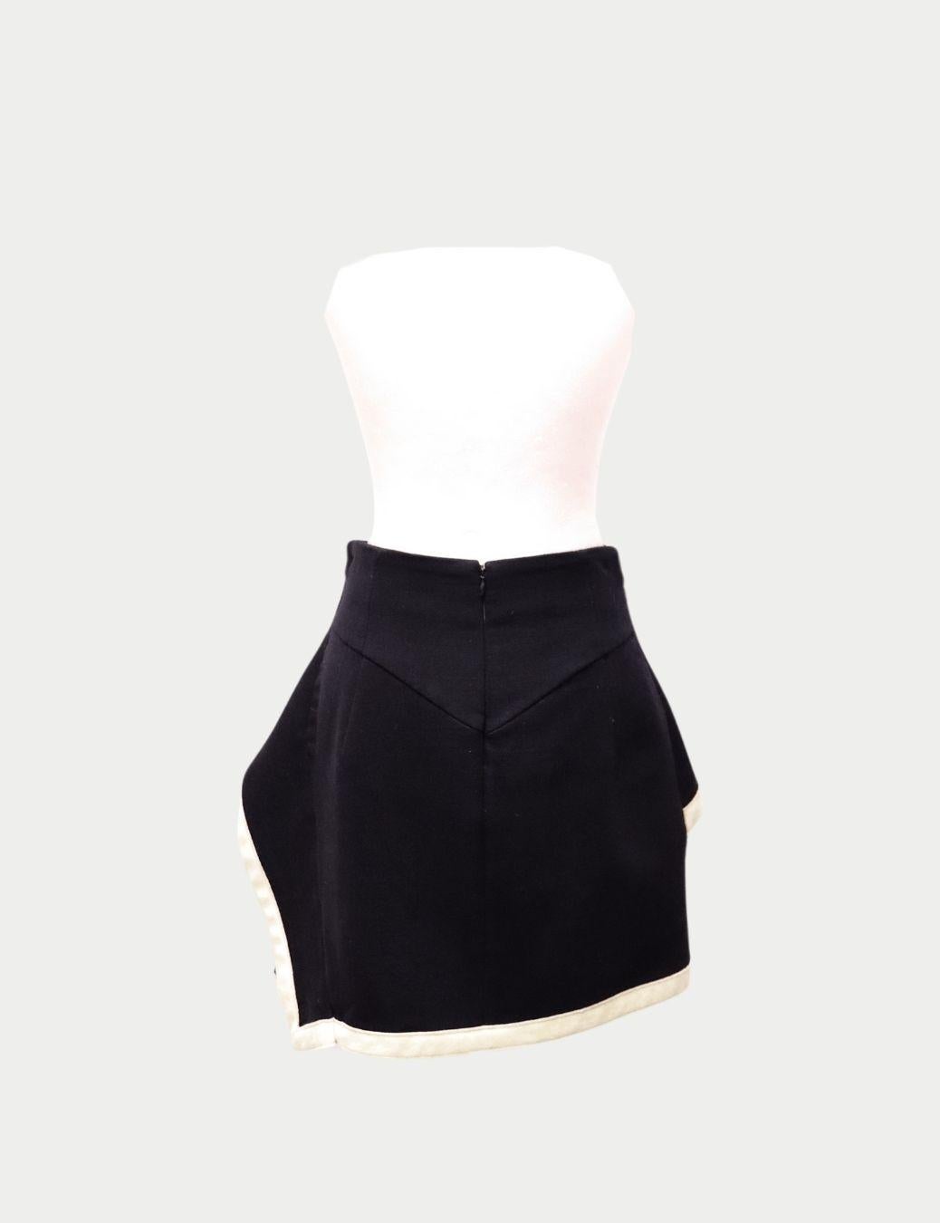 Alexander McQueen Black Layered Mini Skirt – Asymmetric Contrast Trim

This Alexander McQueen Black Layered Mini Skirt captures the brand’s iconic architectural tailoring with a playful, modern twist. Crafted in a structured black fabric, the skirt