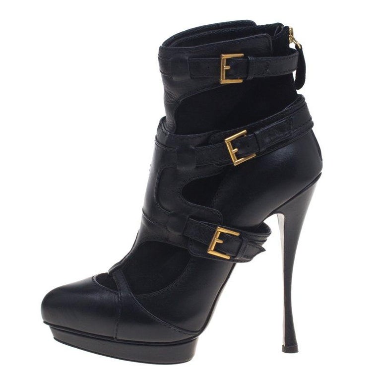 This stunning pair of boots from Alexander Mcqueen are crafted from leather and suede. The ankle length black boots have an angular heel and buckle detailing. The round toe boots have a rear zip fastening. The boots are sure to make heads